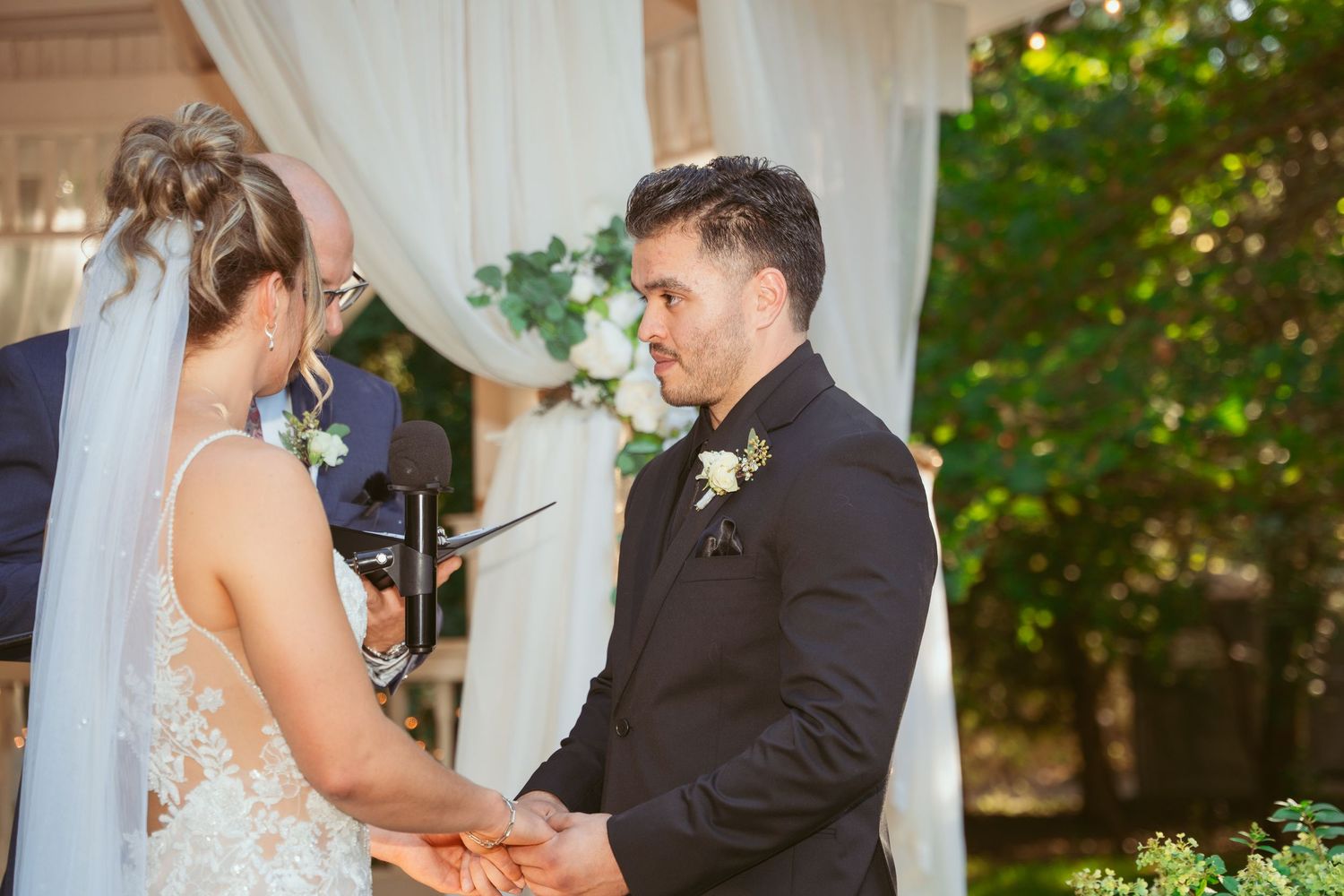 Couple shares intimate moments during their wedding ceremony at a romantic indoor venue.
