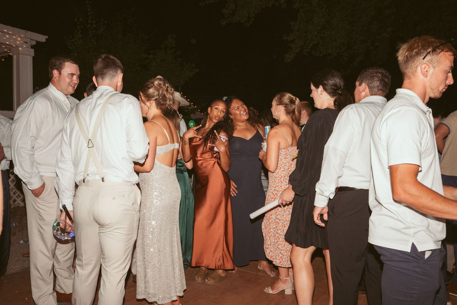 Wedding guests mingling and socializing at an outdoor evening reception.