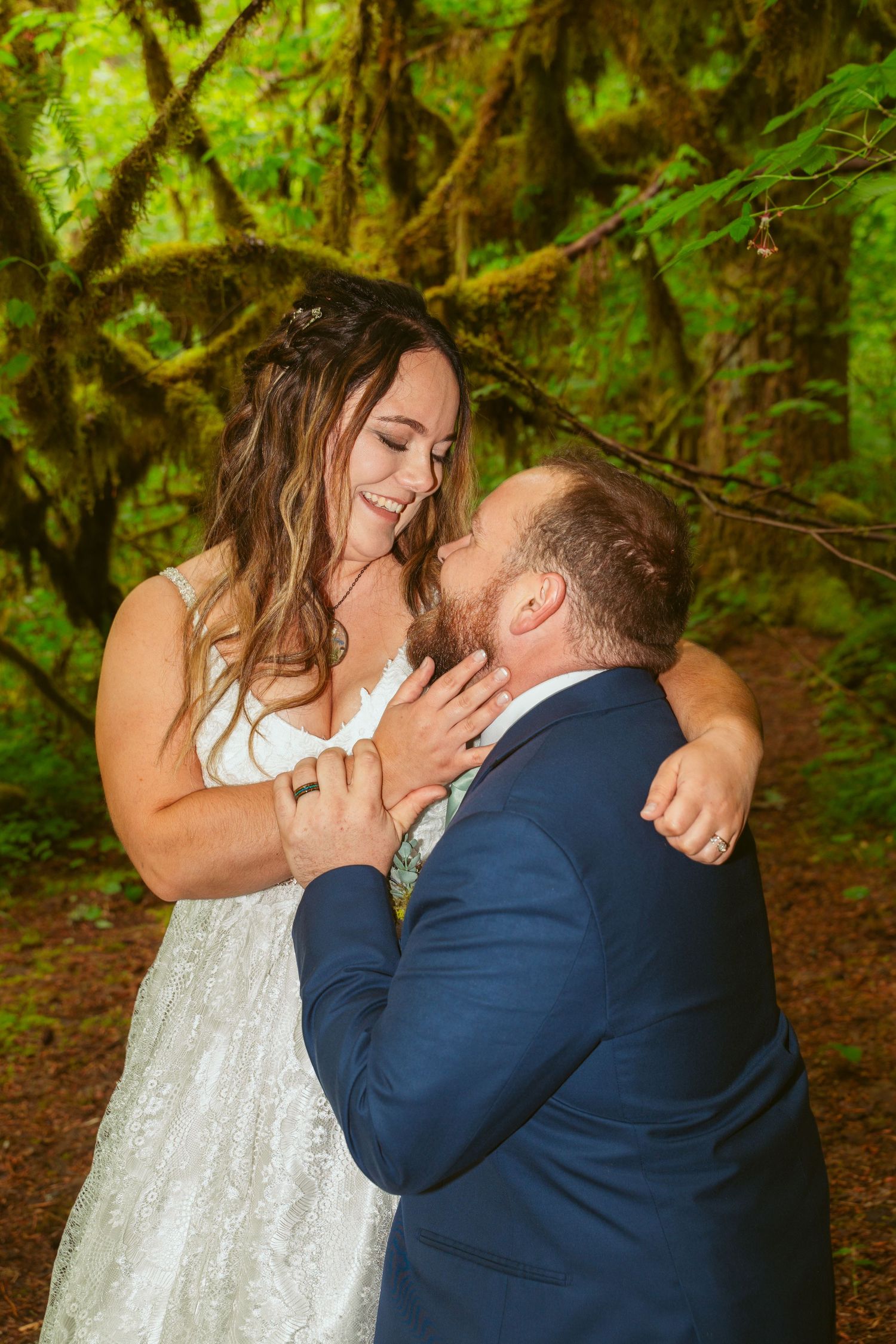 A romantic wedding moment captured in a lush green forest setting.