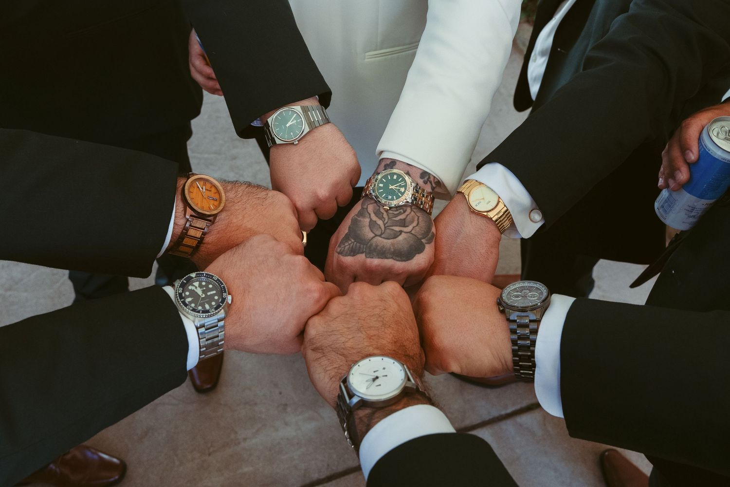 Close-up of formal dress watches being compared on wrists at an event.