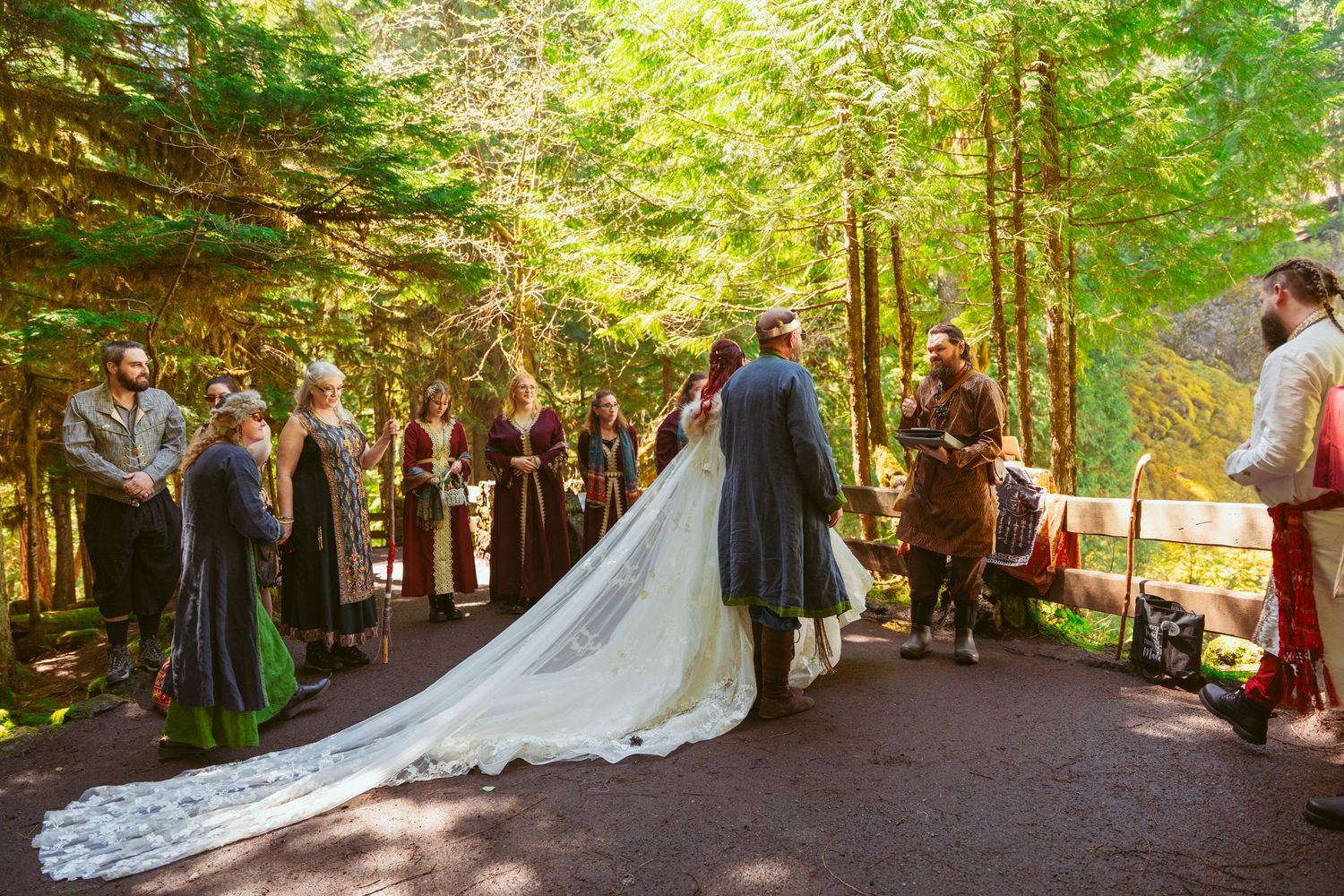 A wedding ceremony procession in a majestic forest setting with medieval-themed decorations.