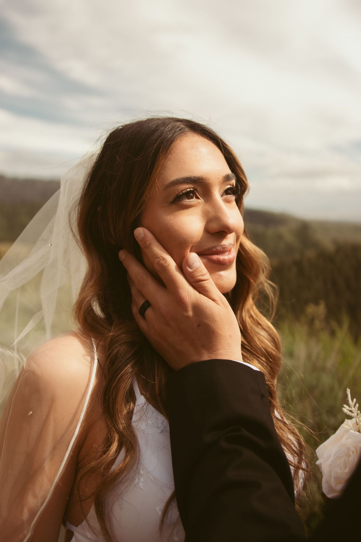 A tender moment captured during an outdoor mountain wedding with scenic valley views.