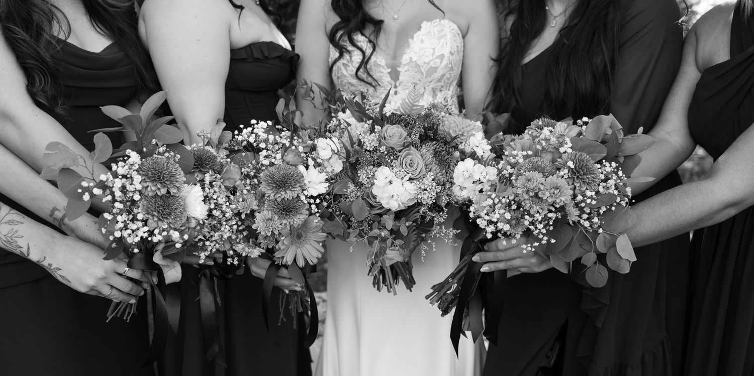 Black and white photo of wedding bouquets held together in a line showing floral arrangement details.