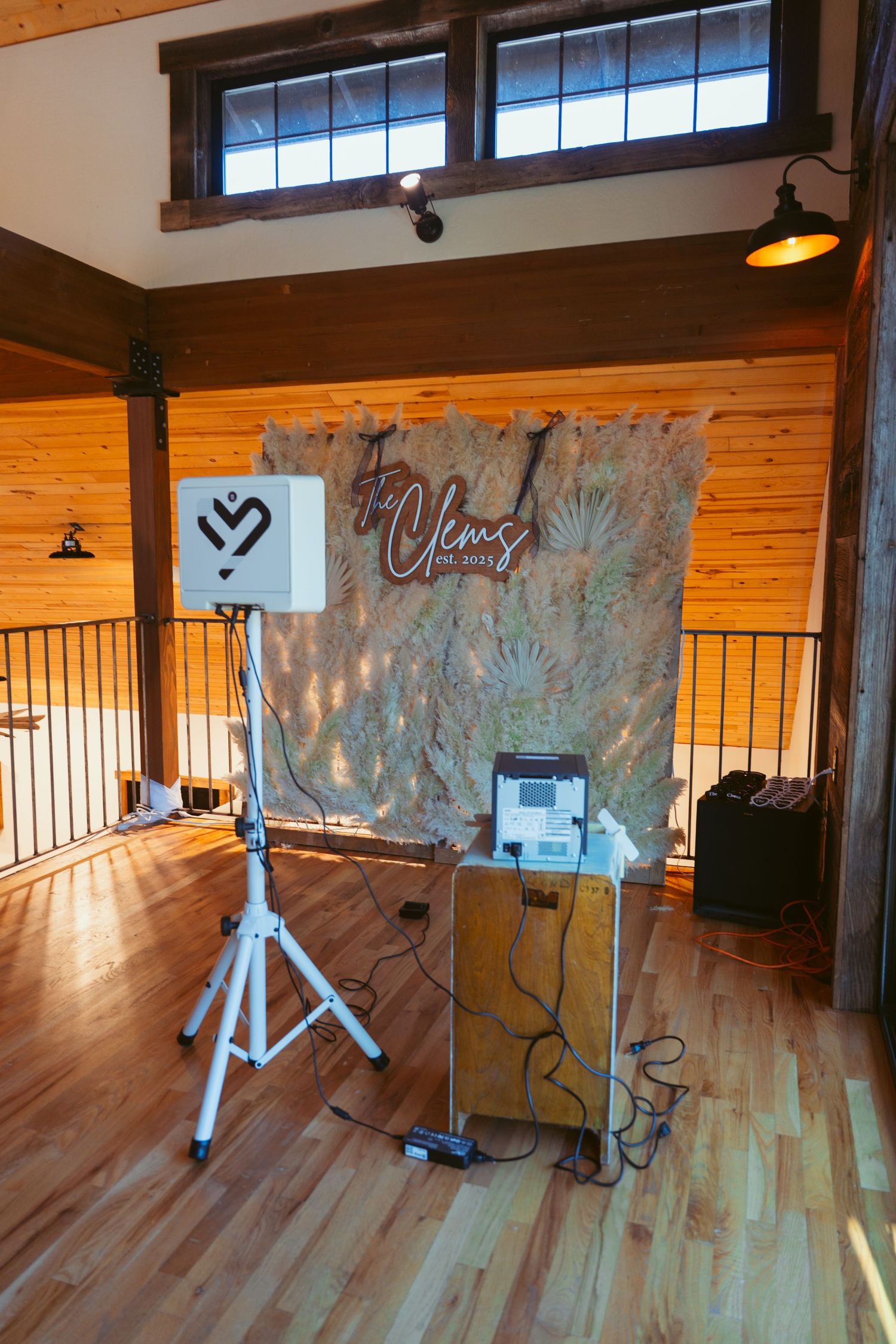 Wooden floored event space with rustic walls and natural lighting from high windows.
