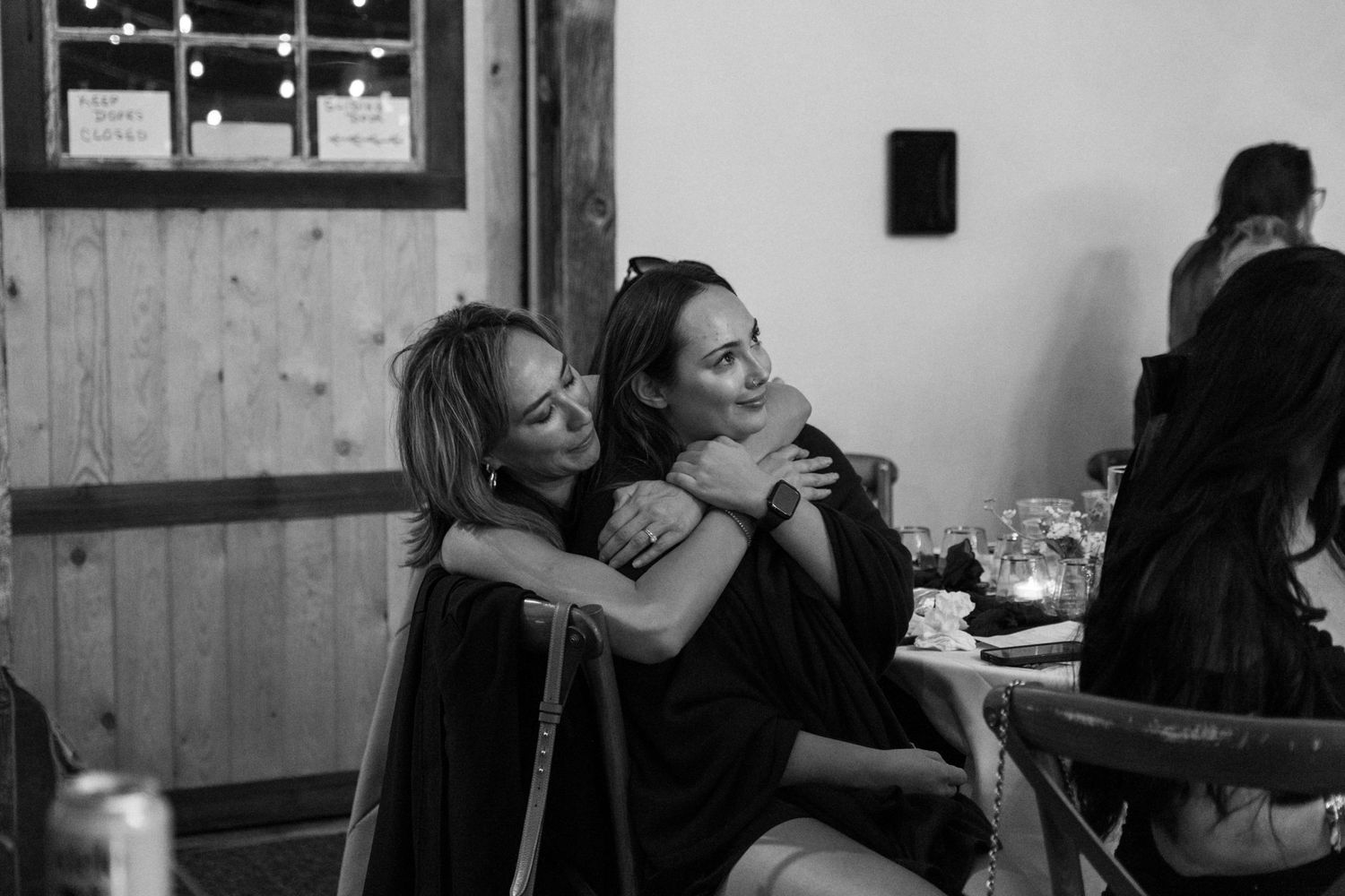 Wedding guests sharing a joyful moment at a rustic reception venue.
