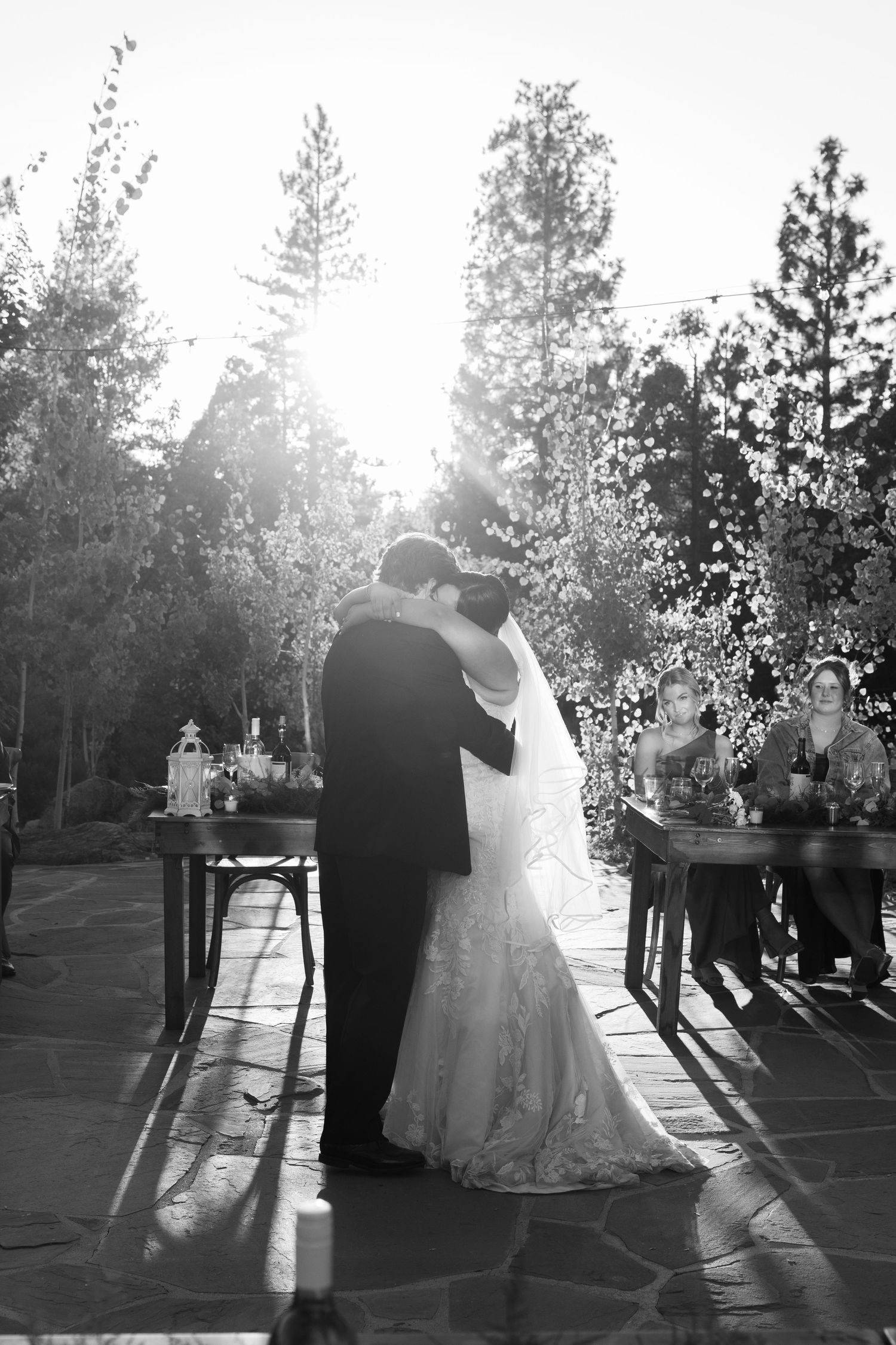 A black and white photo of a couple's first dance at their outdoor wedding reception.