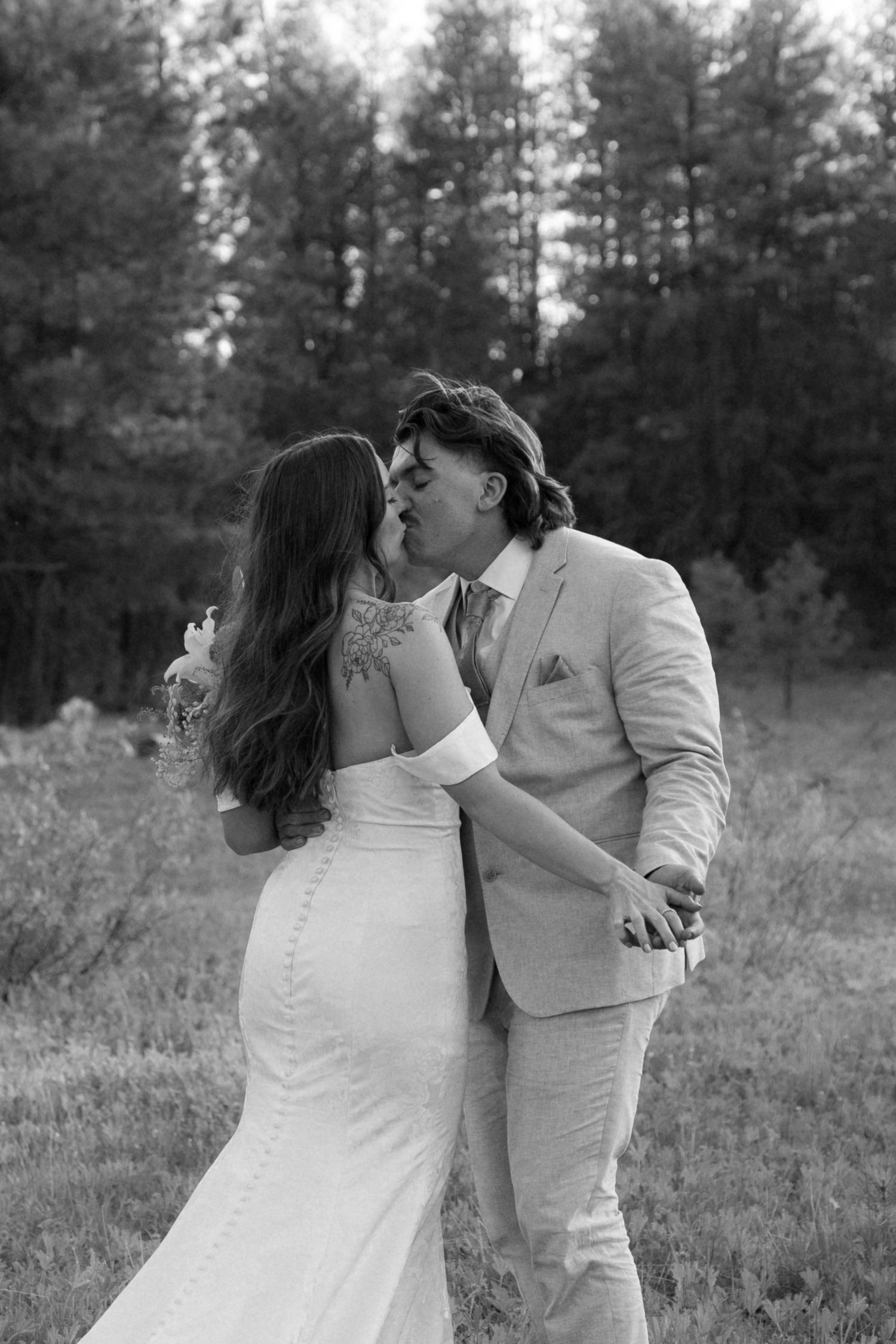 Black and white romantic portrait of newlyweds sharing a kiss.