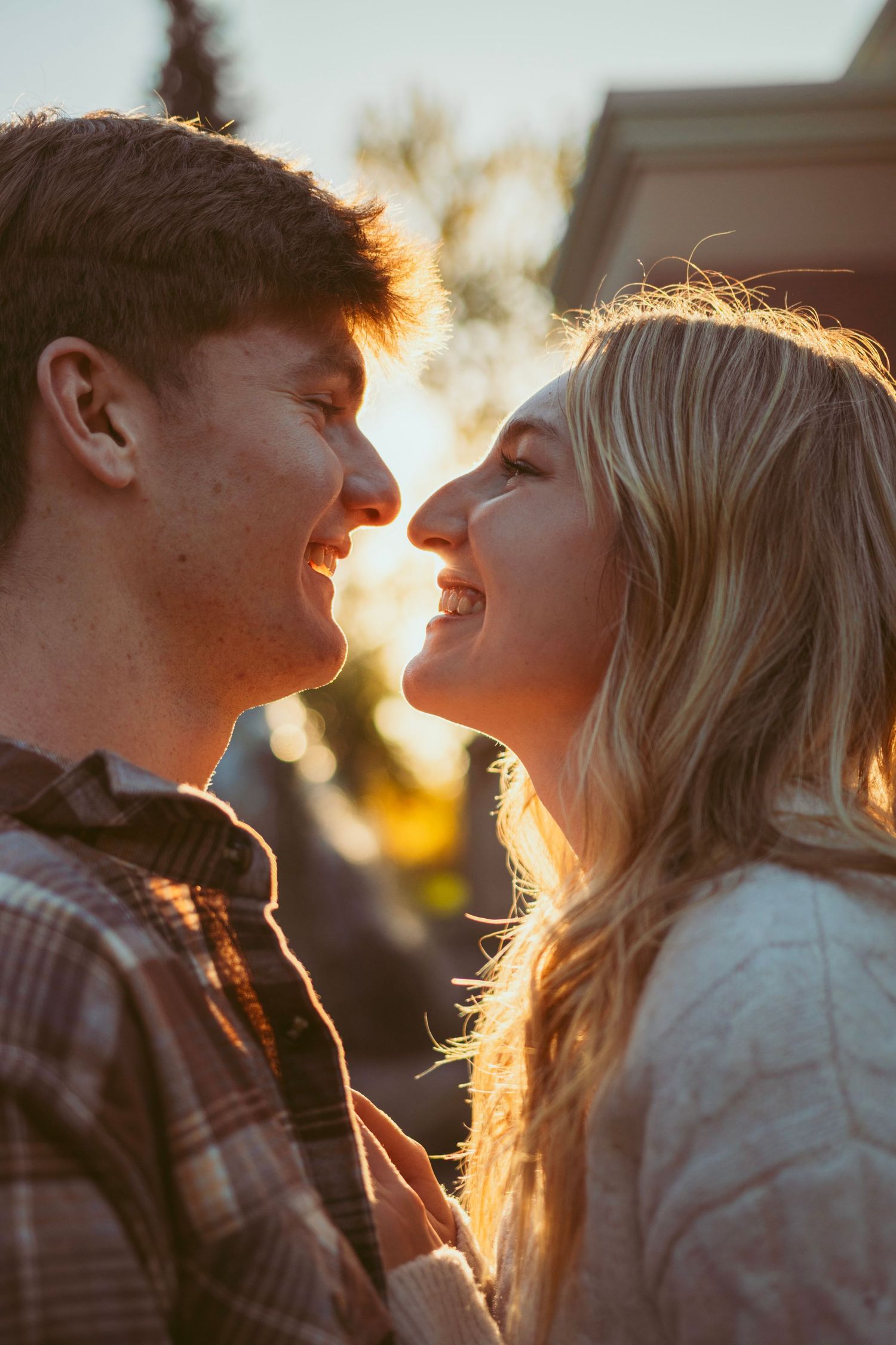 Silhouetted couple sharing intimate moment during golden hour sunset.