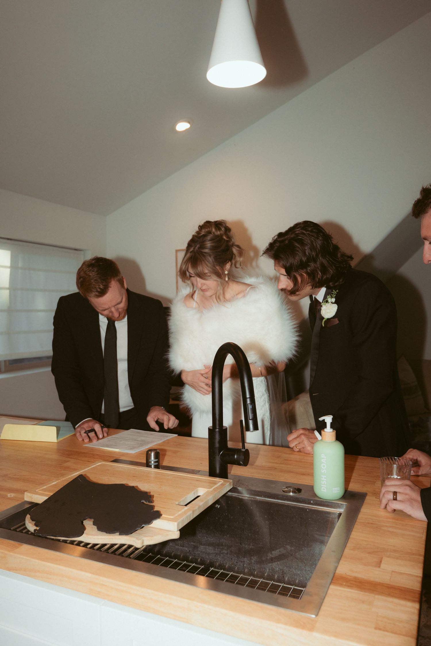 Group reviewing documents together at a modern kitchen counter.