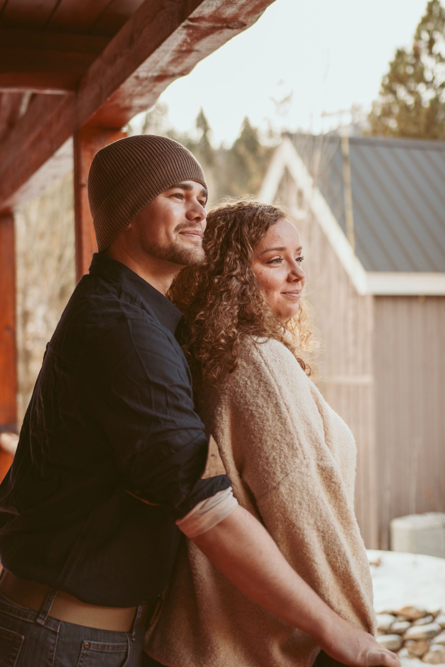 A couple sharing a tender moment on a rustic porch at sunset.
