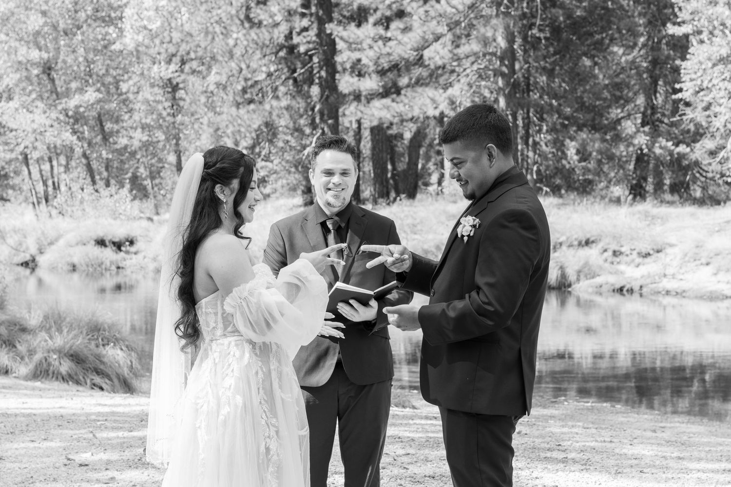An intimate wedding ceremony captured in black and white against a natural backdrop.