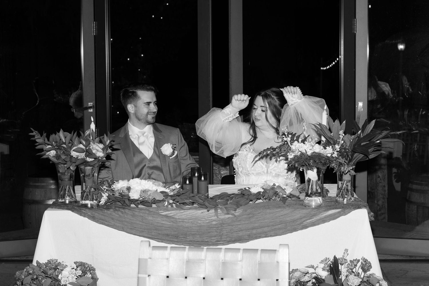Elegant wedding head table with floral decorations and romantic lighting.