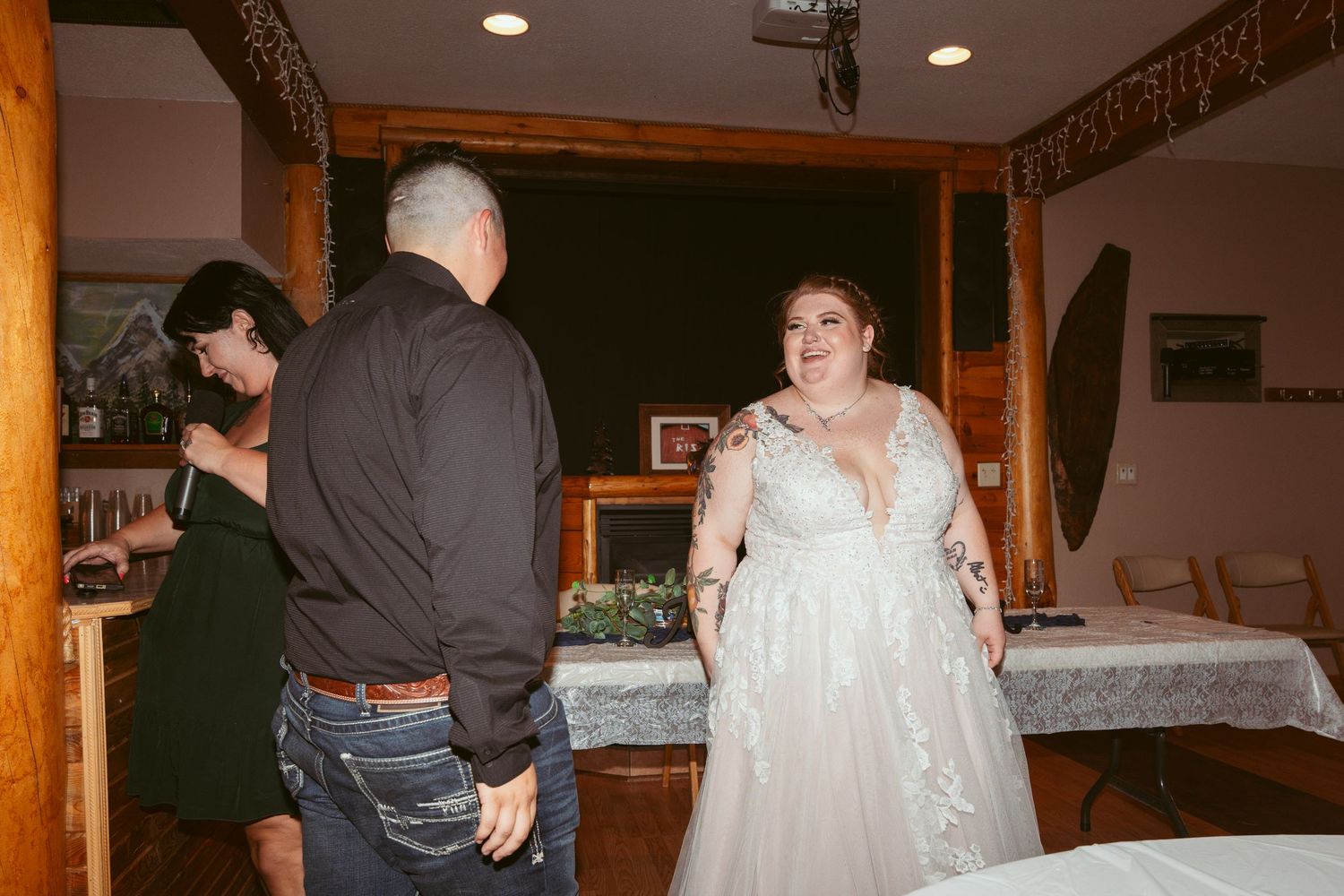 Wedding reception guests gathered inside a rustic wooden lodge venue.