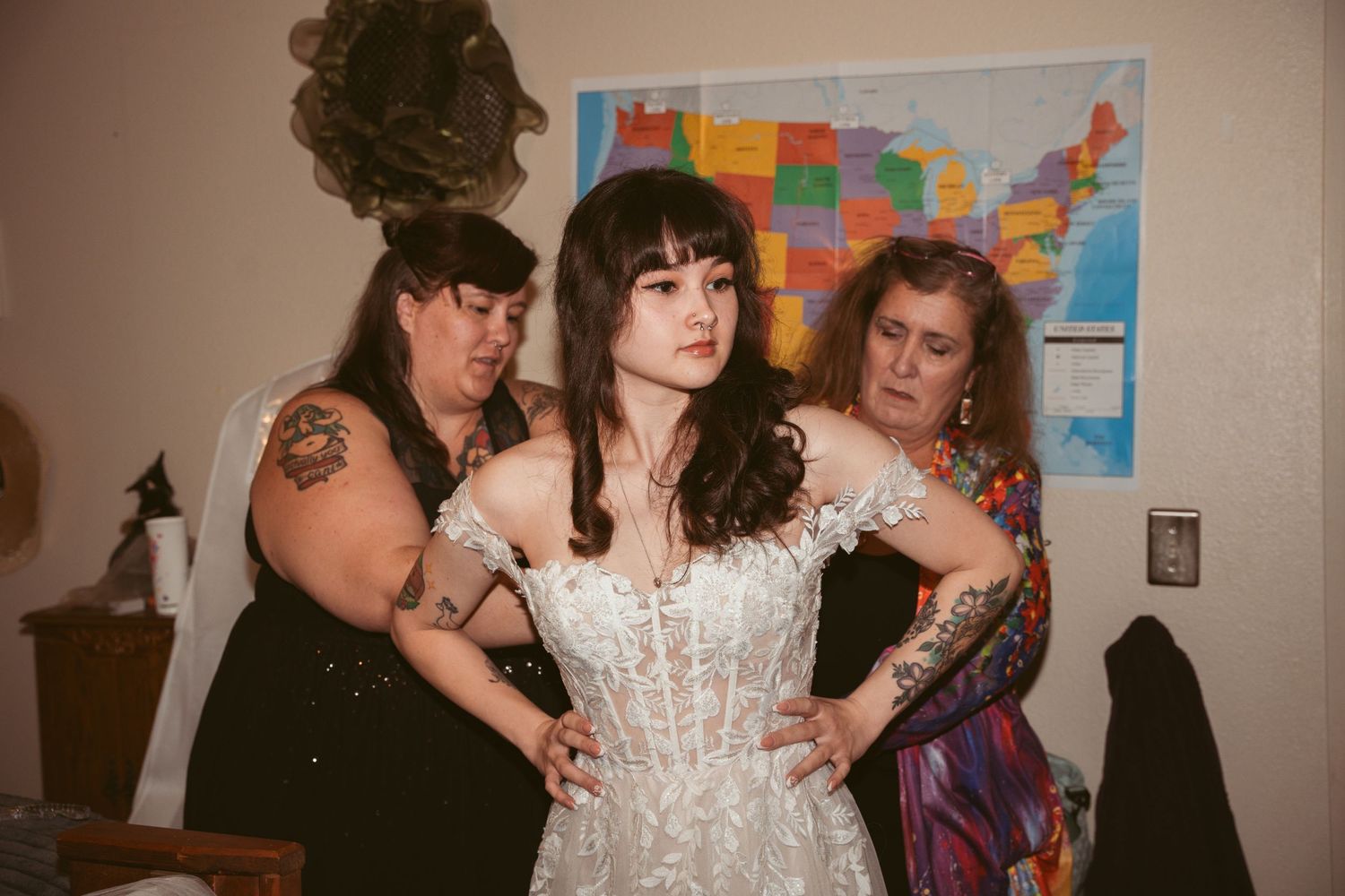 Wedding celebration scene with decorative maps on the wall and guests in the background.