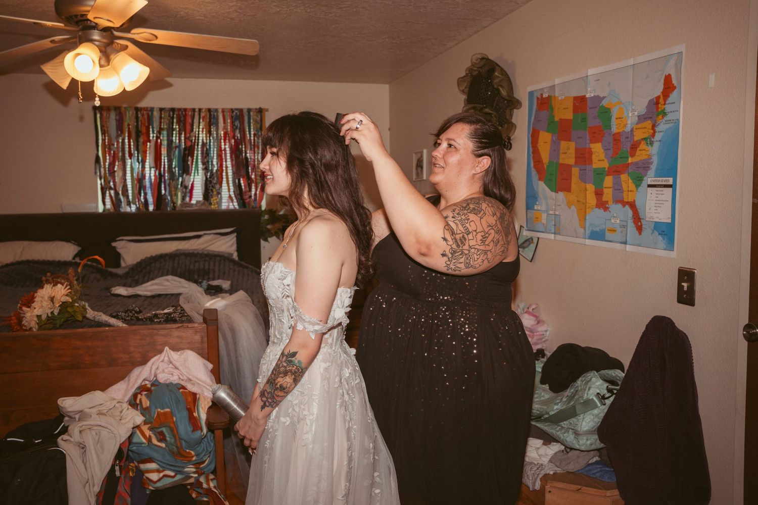 Indoor gathering with people dancing and celebrating under ceiling fans.