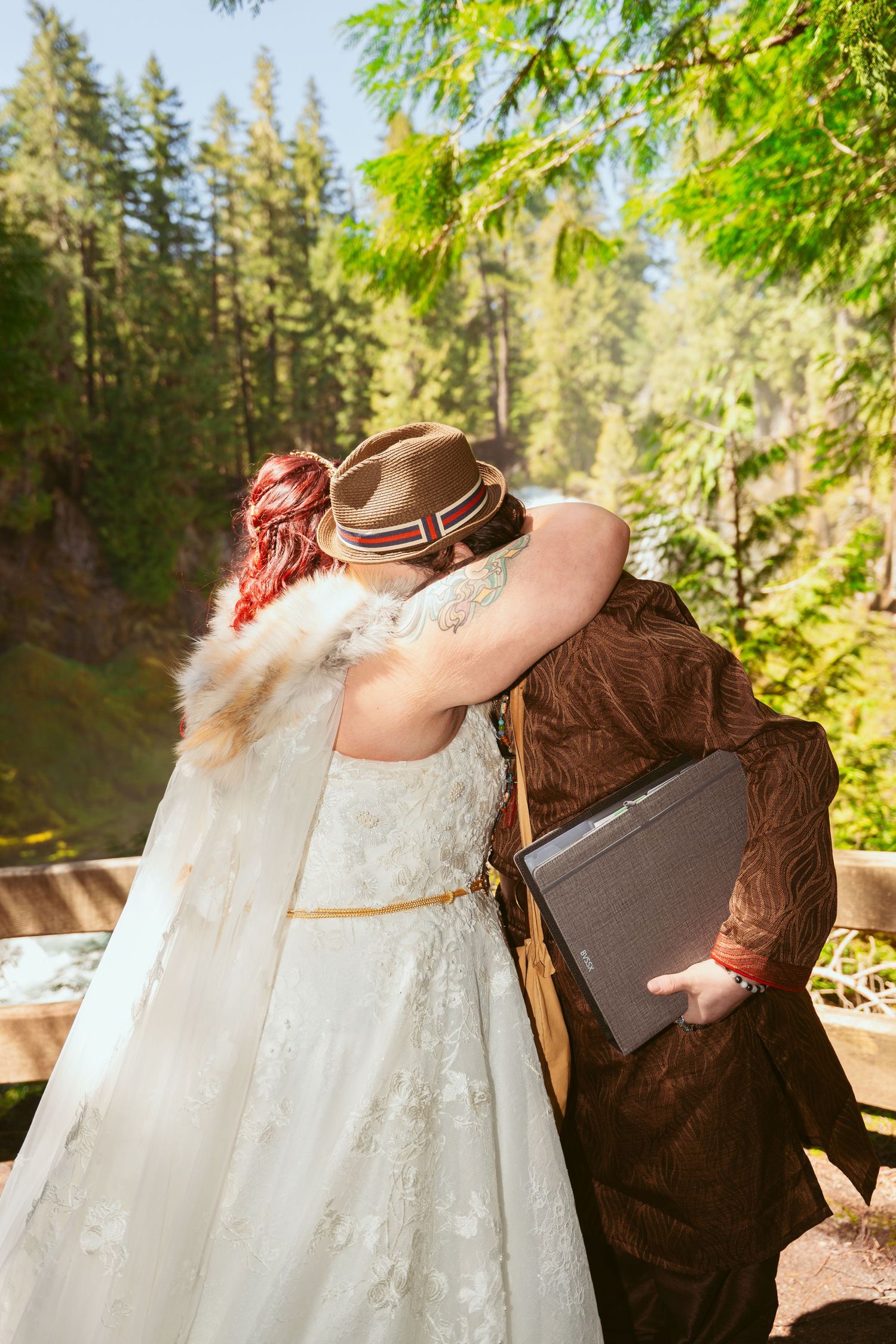 A flowing white wedding dress contrasts with dark medieval attire in a sunlit forest setting.
