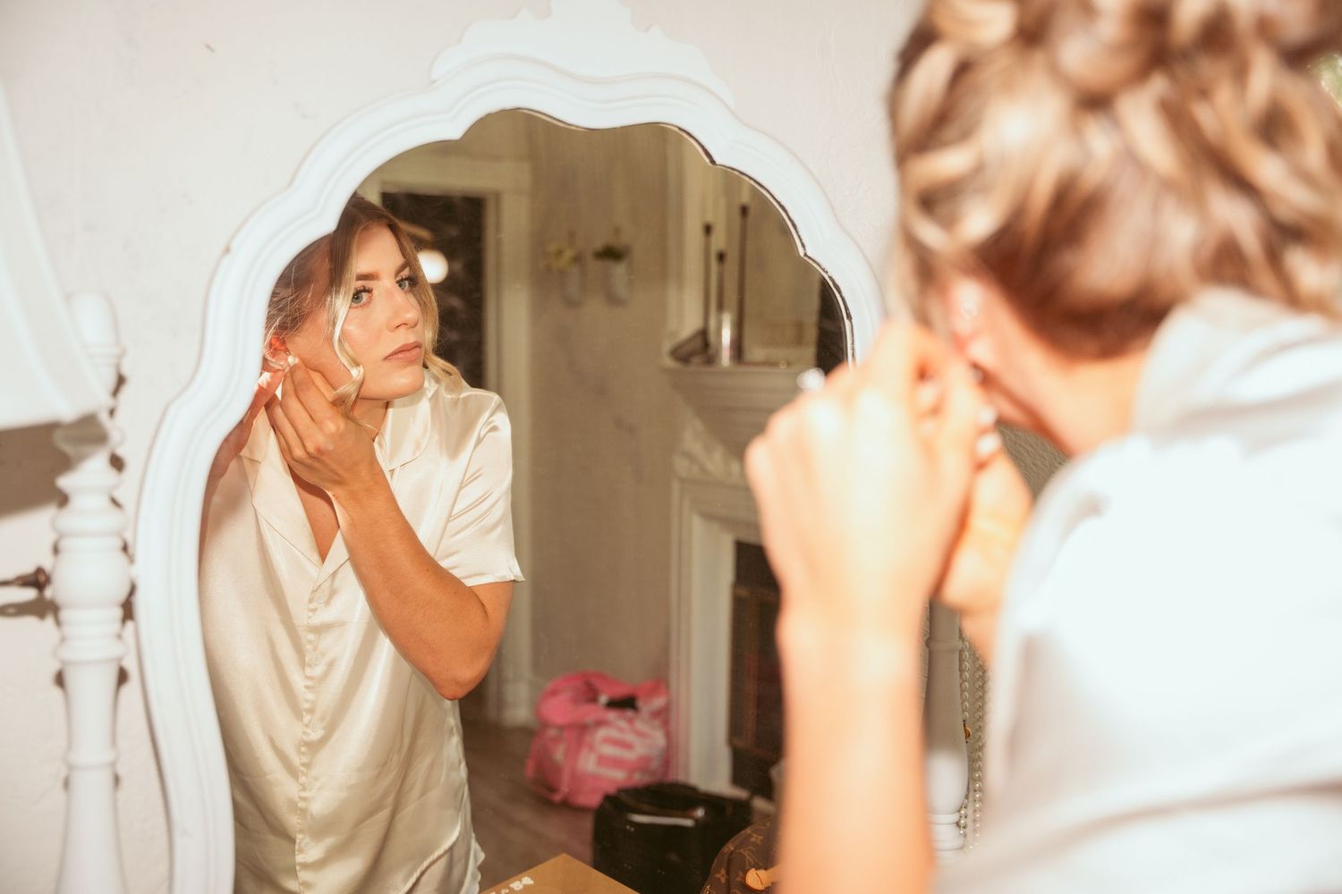 Getting ready moments captured in mirrors showing final touches of wedding day preparations.