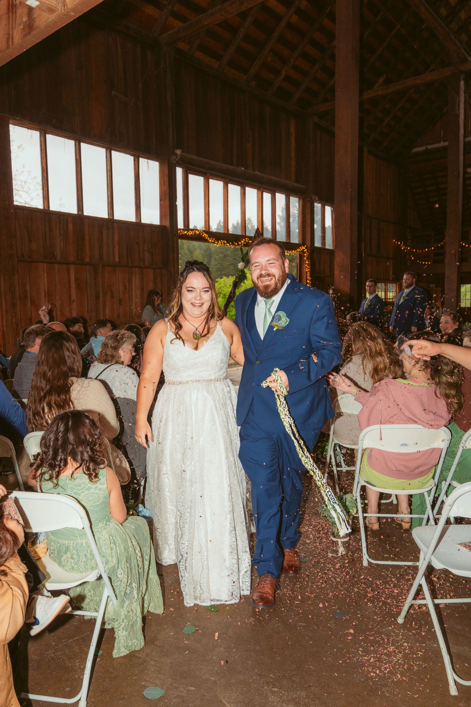 Celebratory moment with confetti being thrown during a barn wedding reception.