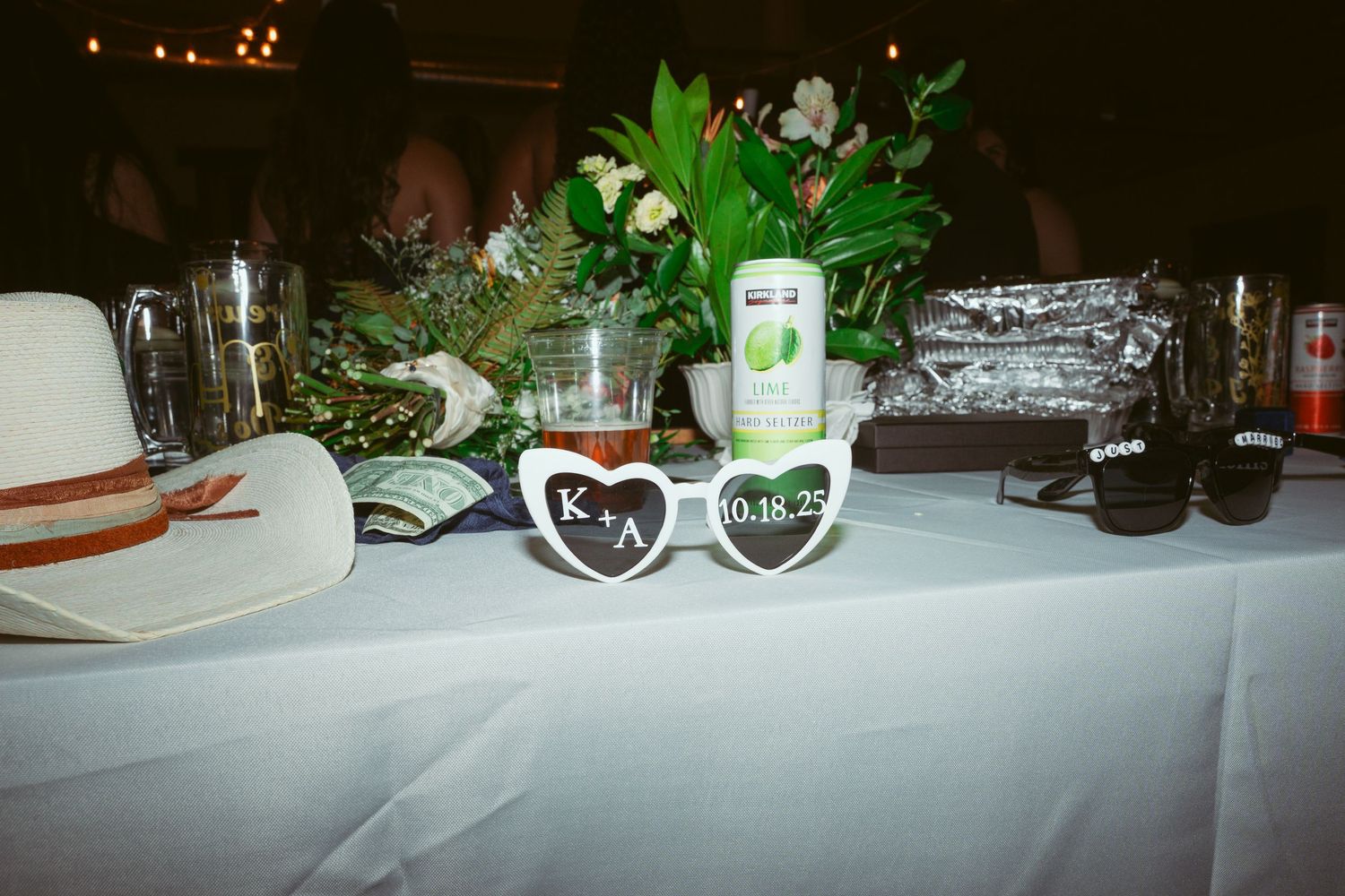 Decorated reception table with wine glasses, centerpieces and place settings.