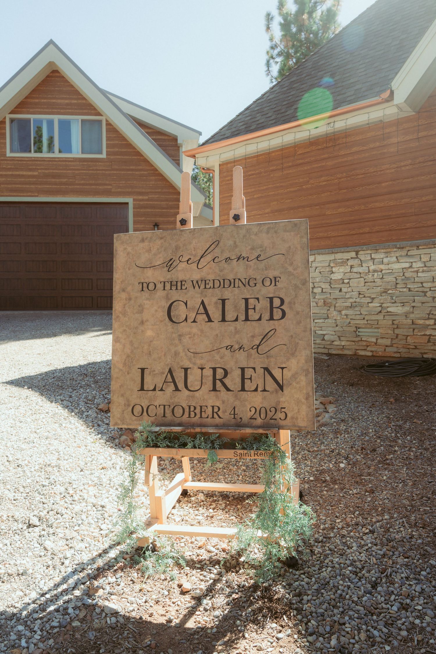 Wooden welcome signs displayed on stakes in a garden setting.