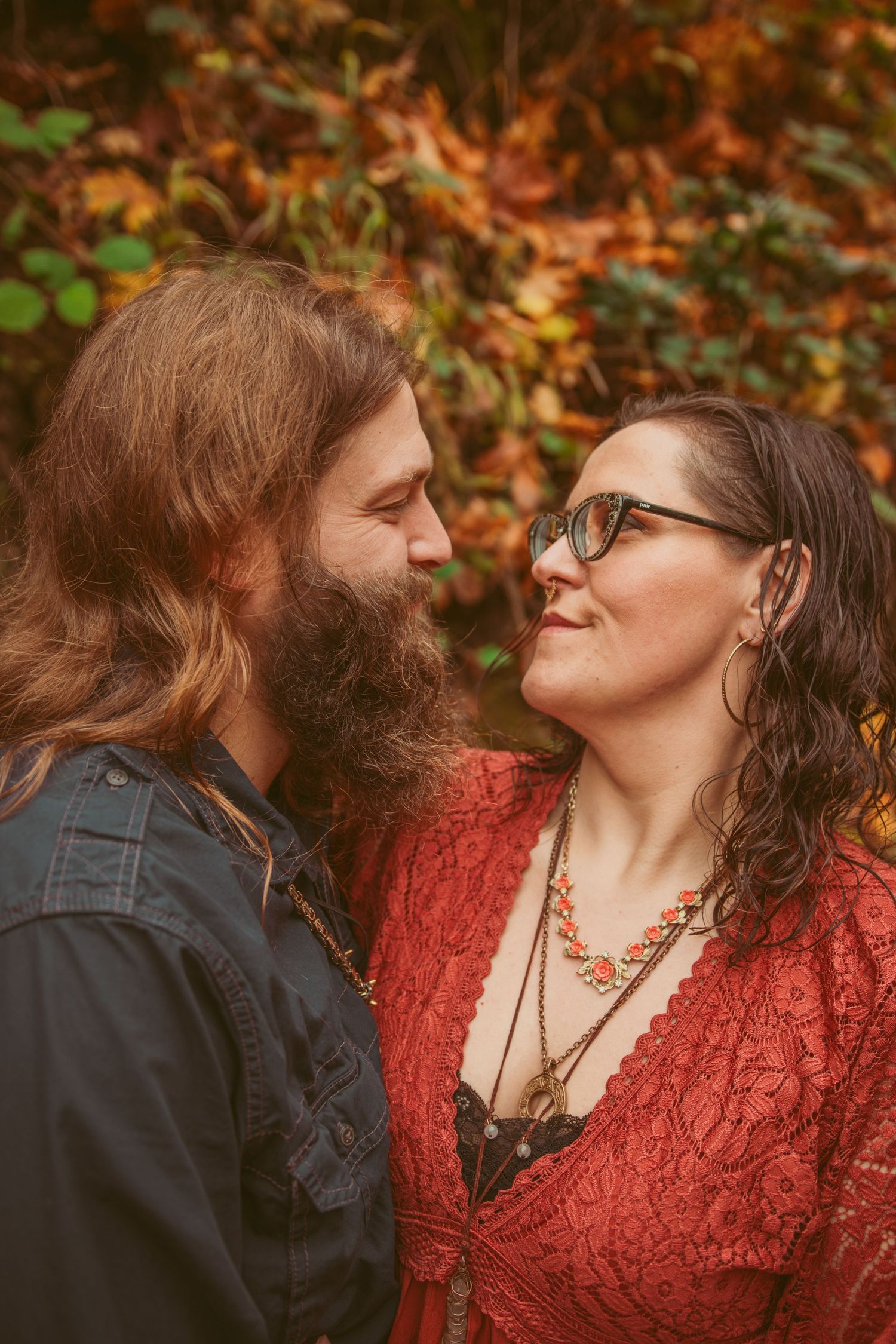 A tender moment captured between two people against a backdrop of autumn colors.
