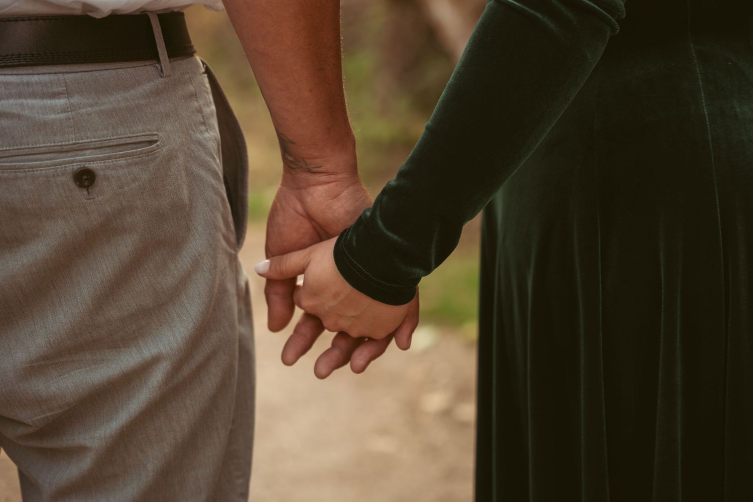 Intimate close-up of hands touching during a romantic moment outdoors.