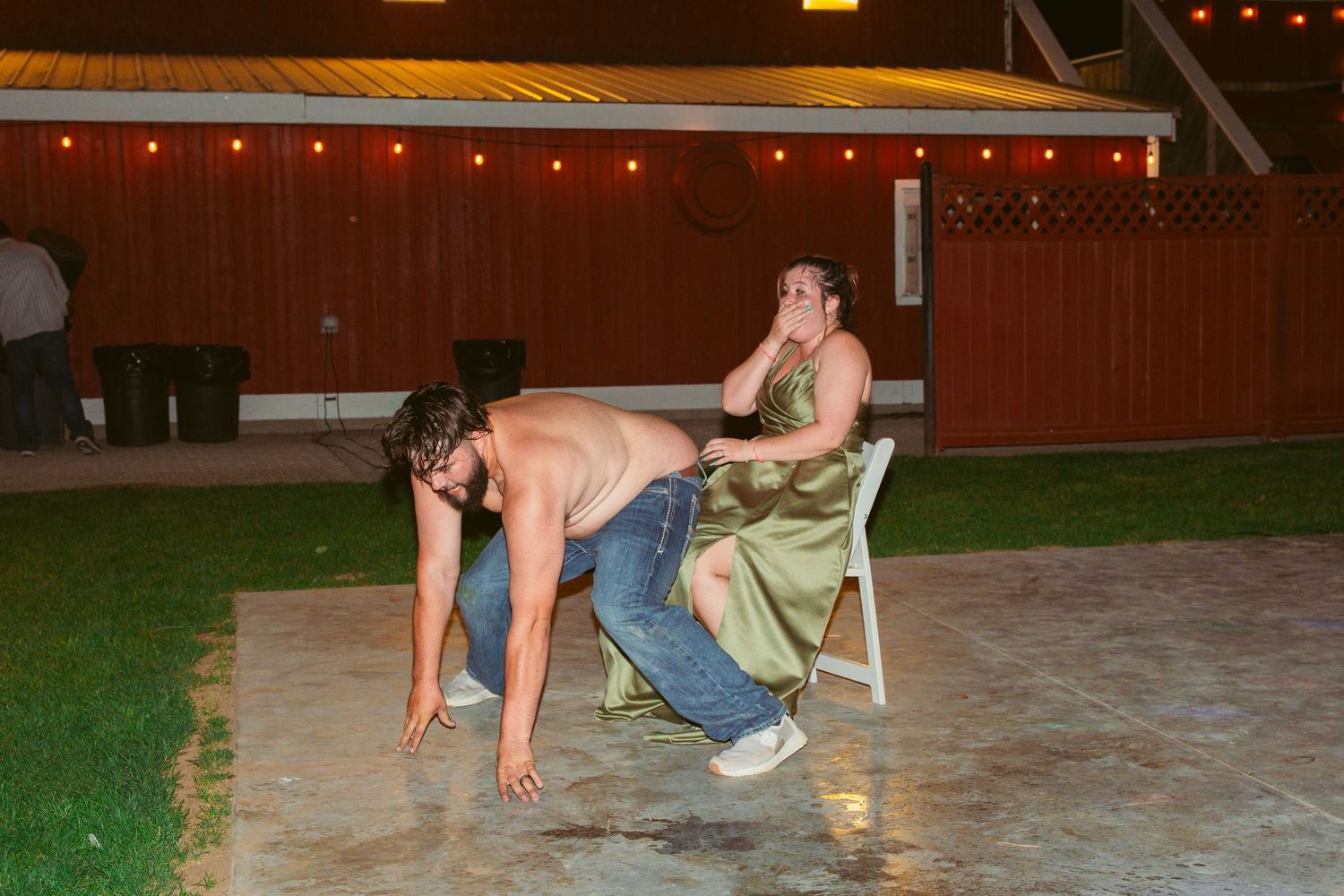 Party guests engage in playful poses on an outdoor dance floor at night.