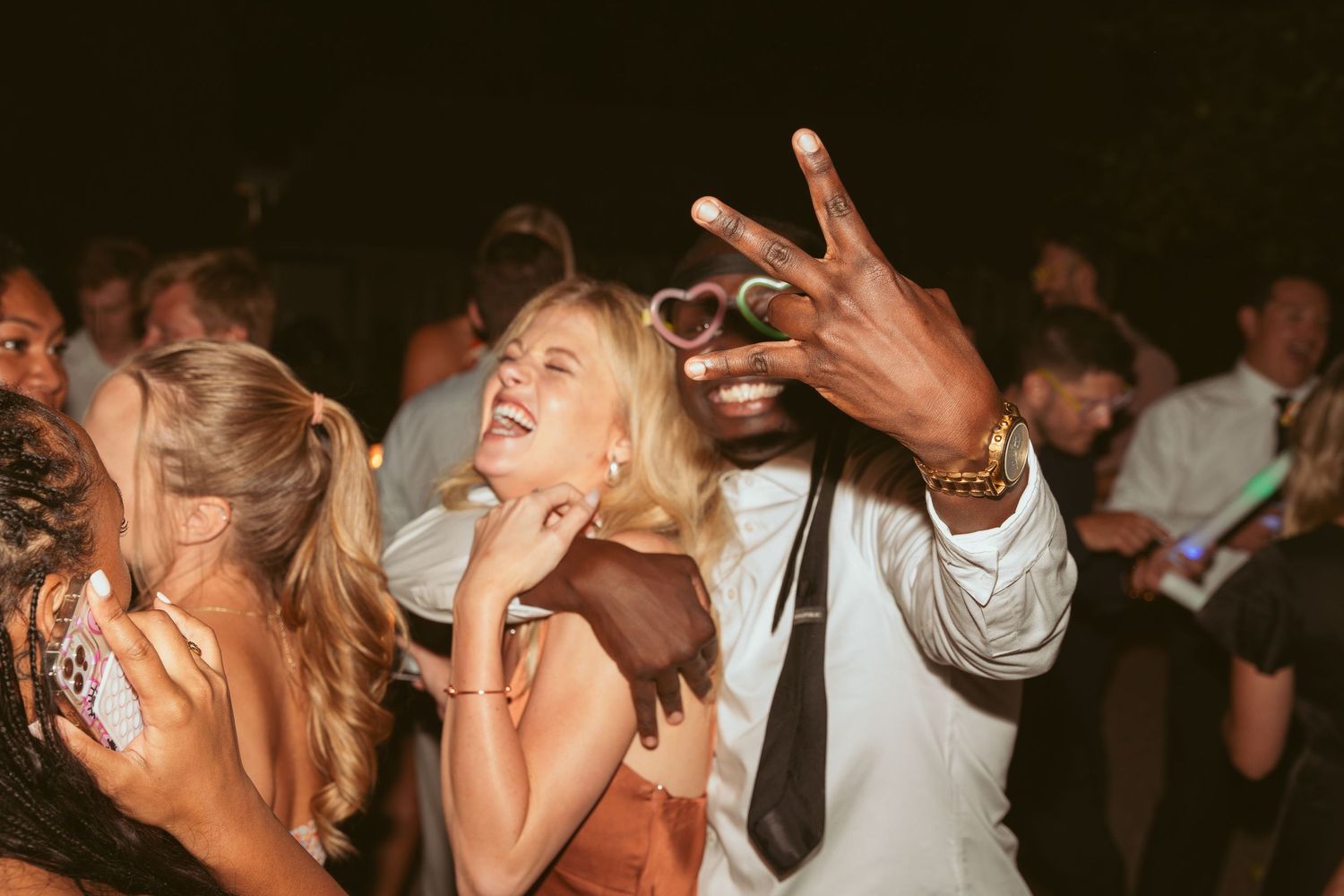 Party guests dancing enthusiastically at a nighttime celebration.