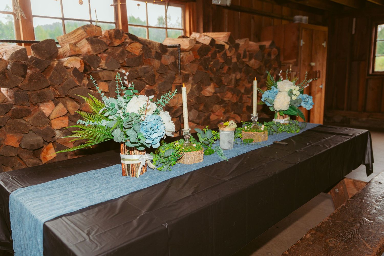 Stone wall backdrop with floral arrangements and decor for a wedding ceremony.