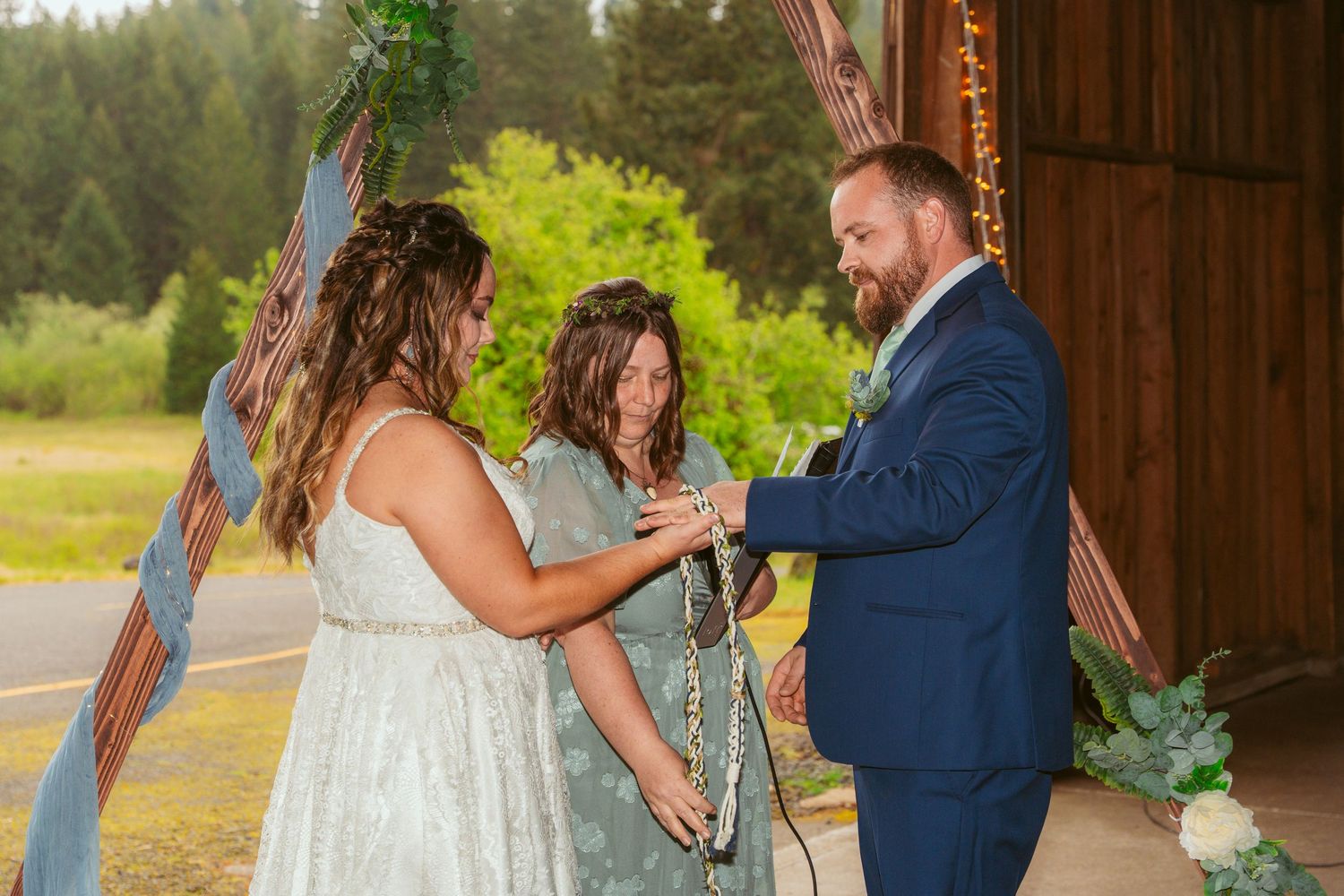 Wedding celebration moments captured inside wooden barn with greenery decorations.