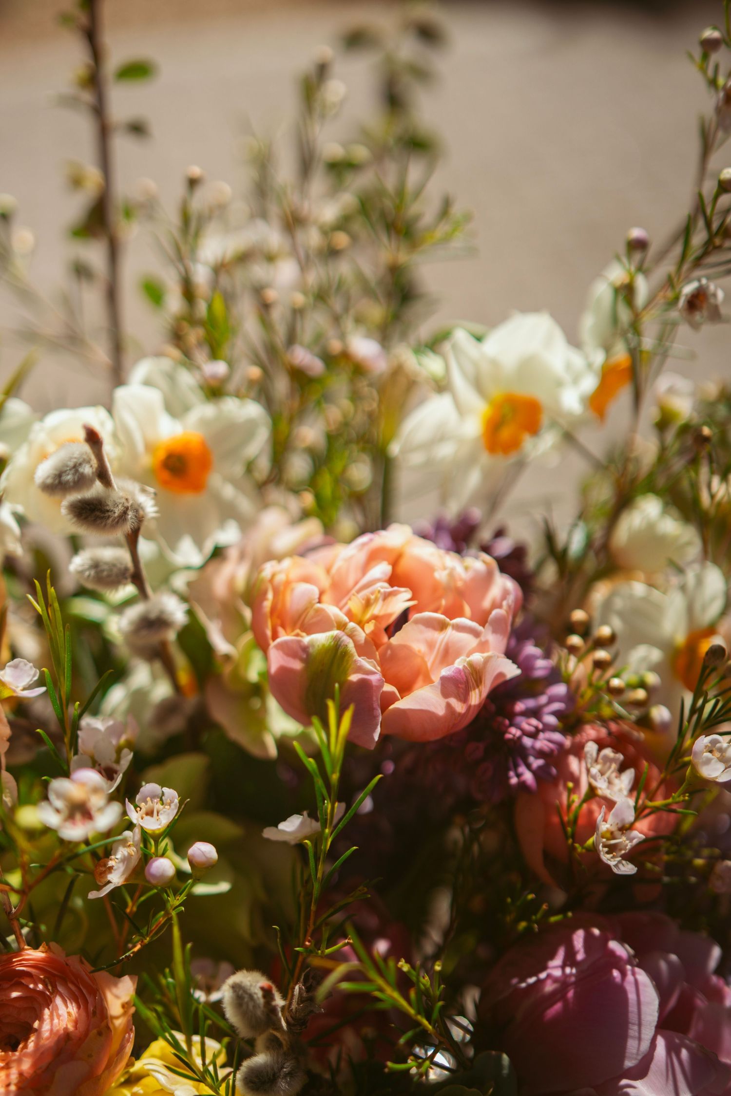 Delicate pink and white flowers with greenery arranged in a romantic garden-style floral display.