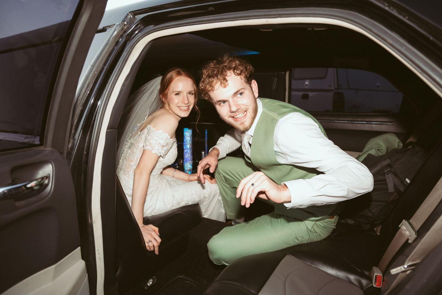 Wedding couple getting into their getaway car at the end of their celebration.