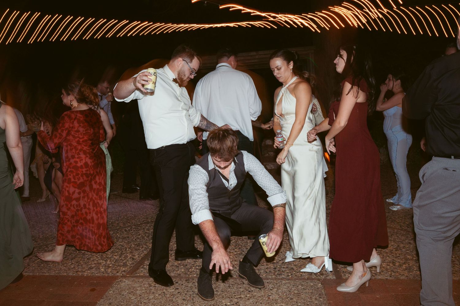Wedding guests dancing and having fun on the dance floor at an evening celebration.