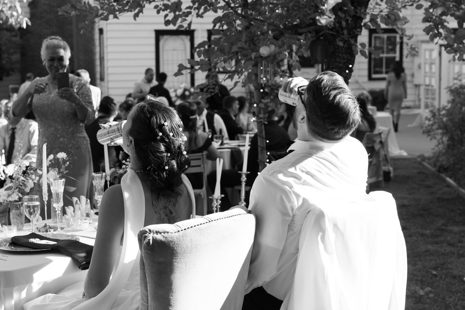Wedding guests dancing and celebrating outdoors in formal attire.