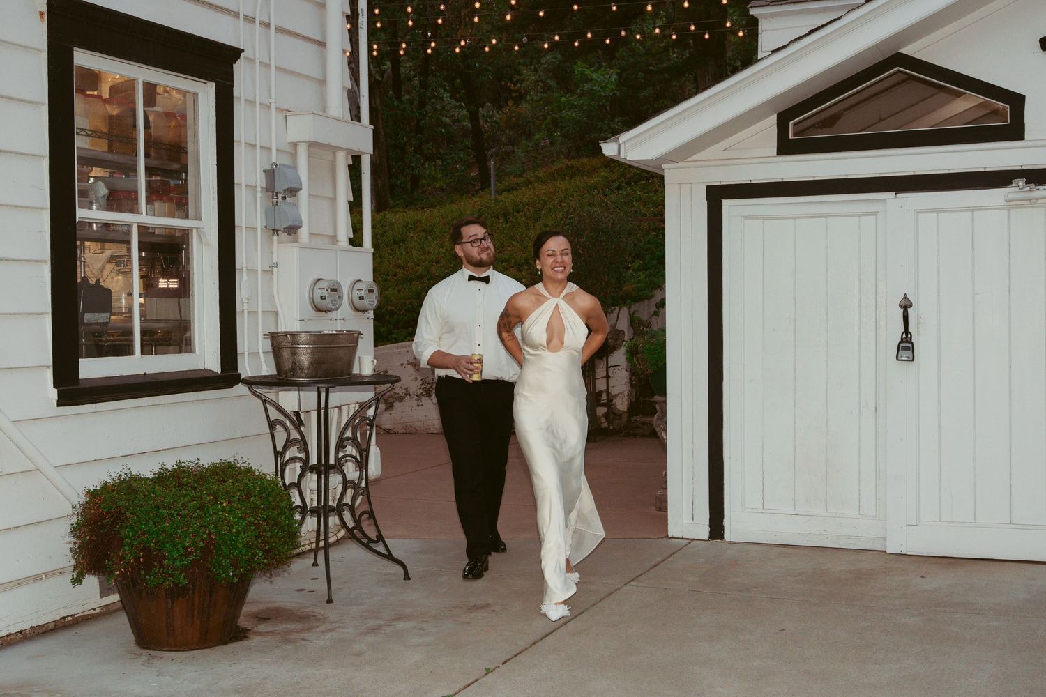 Wedding venue exterior with white buildings and string lights creating a romantic atmosphere.