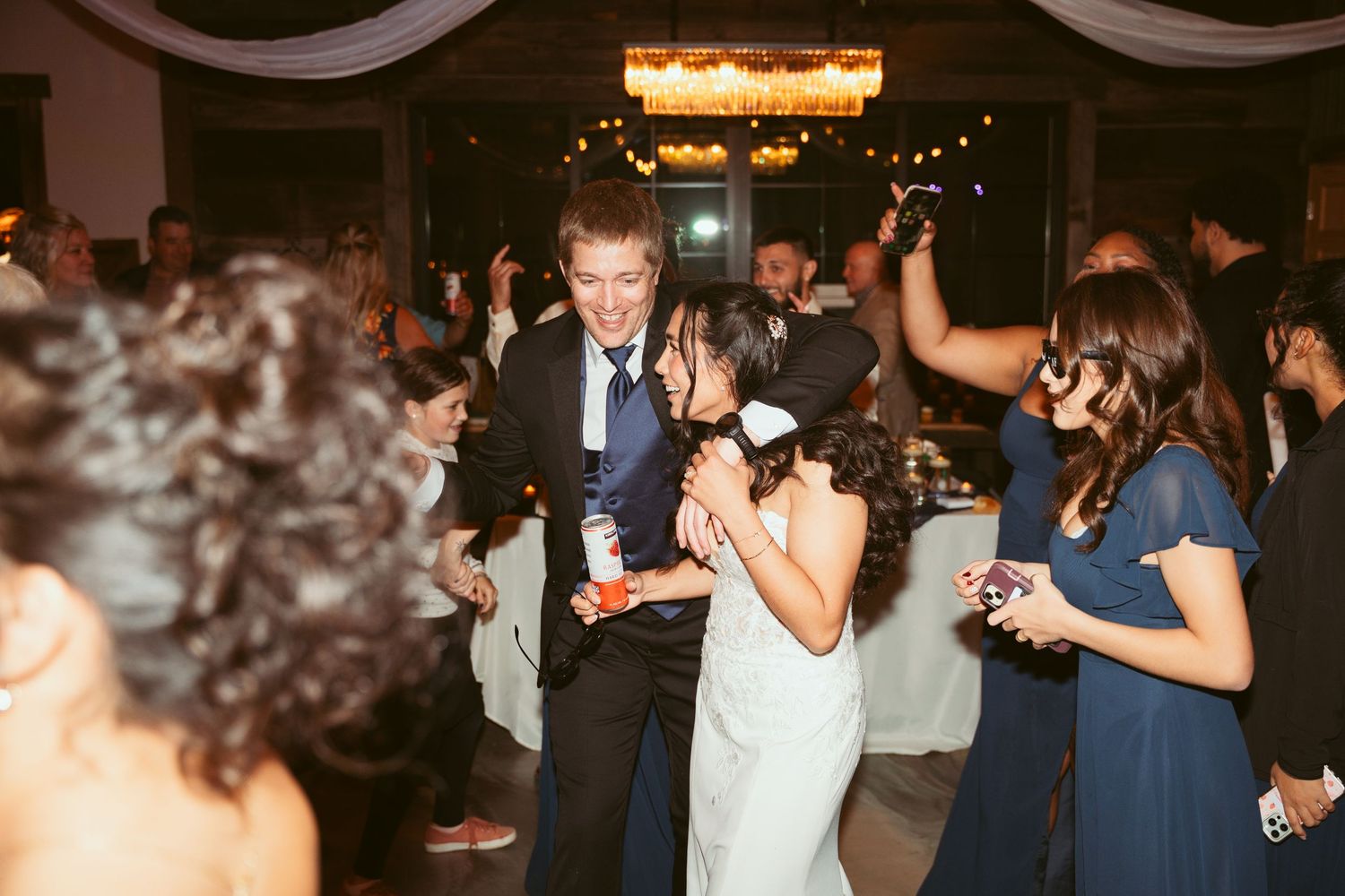 Lively dance floor scene at an indoor celebration with atmospheric lighting and decorations.