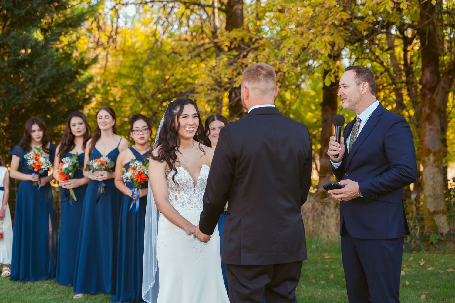 Outdoor wedding ceremony scene with golden fall foliage backdrop.