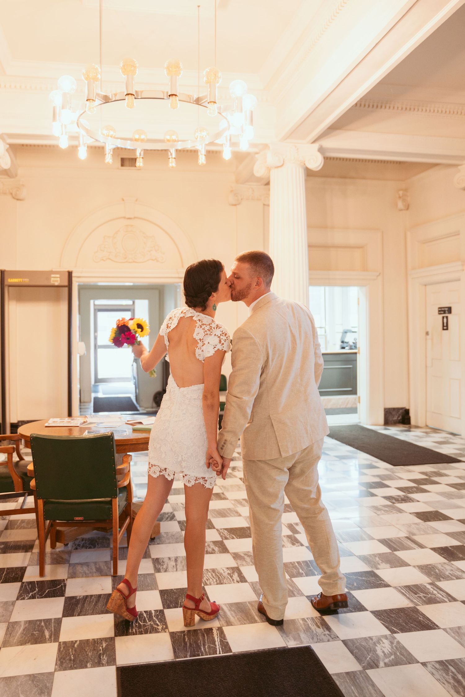 A couple shares intimate moments on a black and white checkered floor.