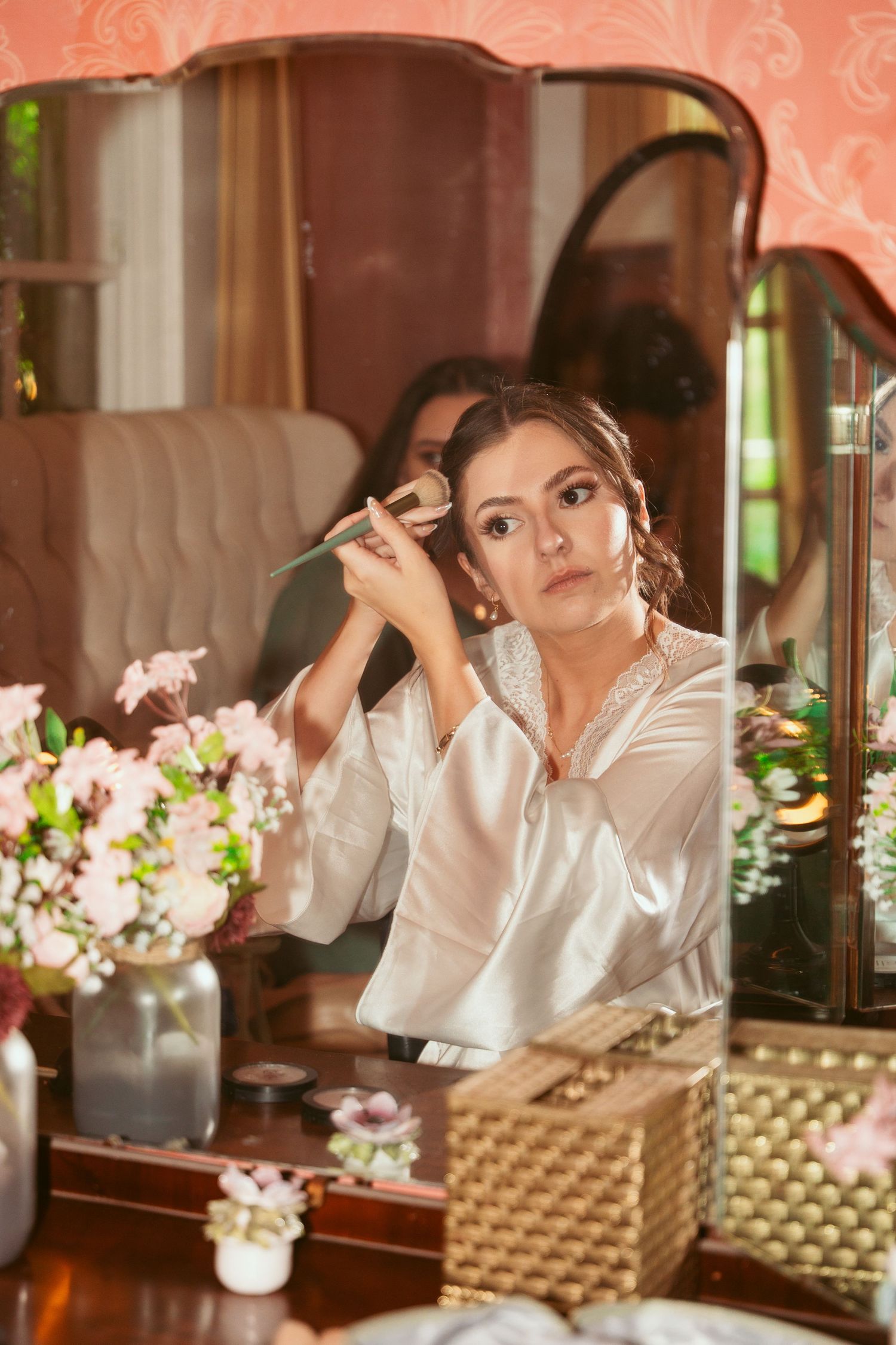 Elegant vintage-style dressing table setup with fresh flowers and mirror reflections.