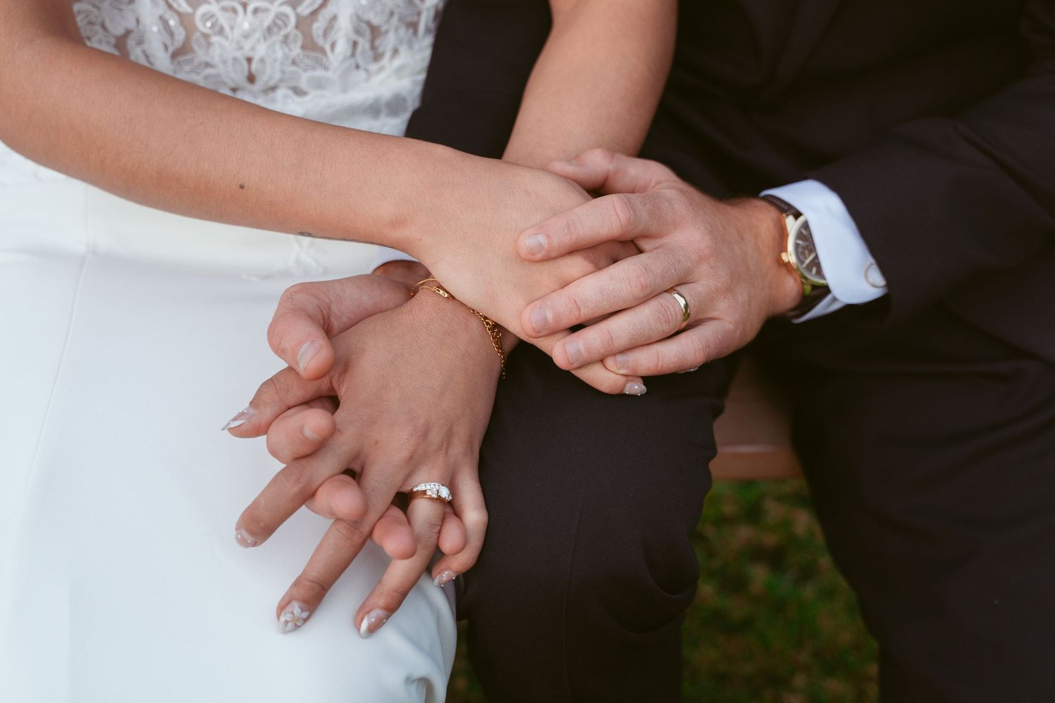 Close-up detail of hands with wedding rings in intimate moment.