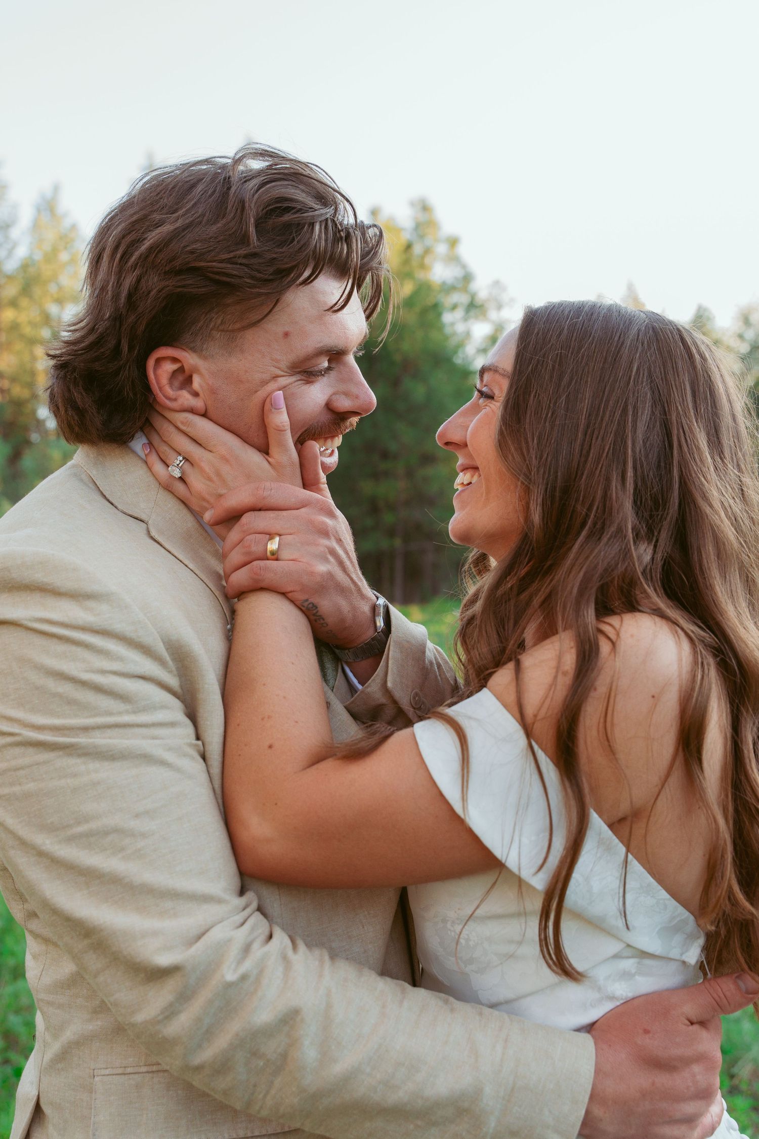 Romantic wedding couple sharing intimate moments in a natural outdoor setting.