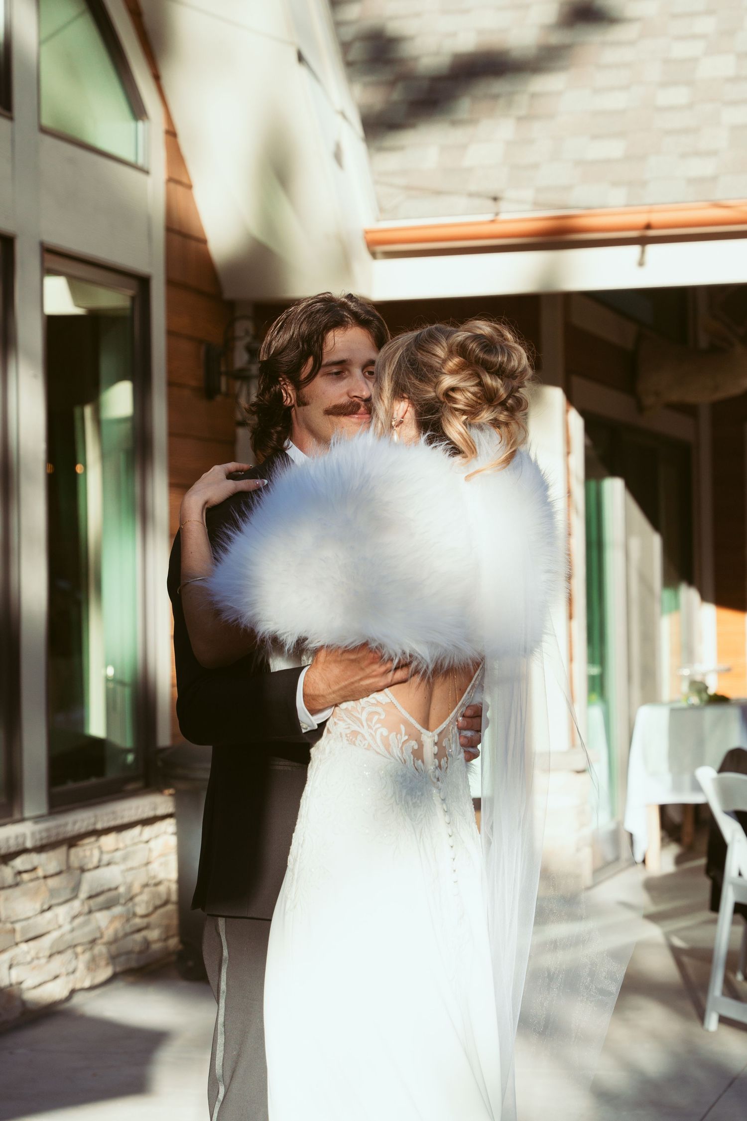 A tender embrace between newlyweds during their outdoor wedding celebration.