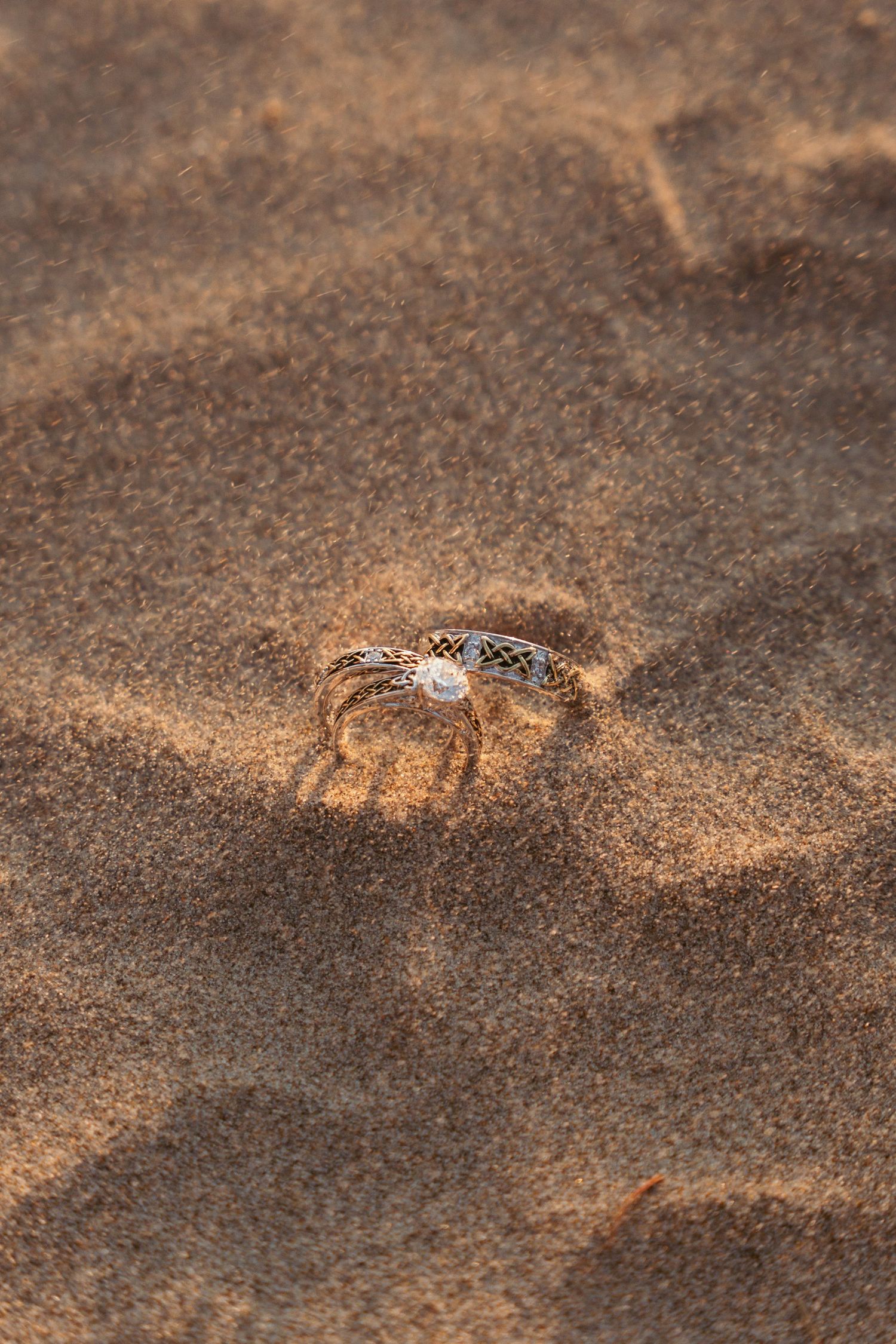 Close-up texture of golden sand with subtle patterns and shadows on a beach.