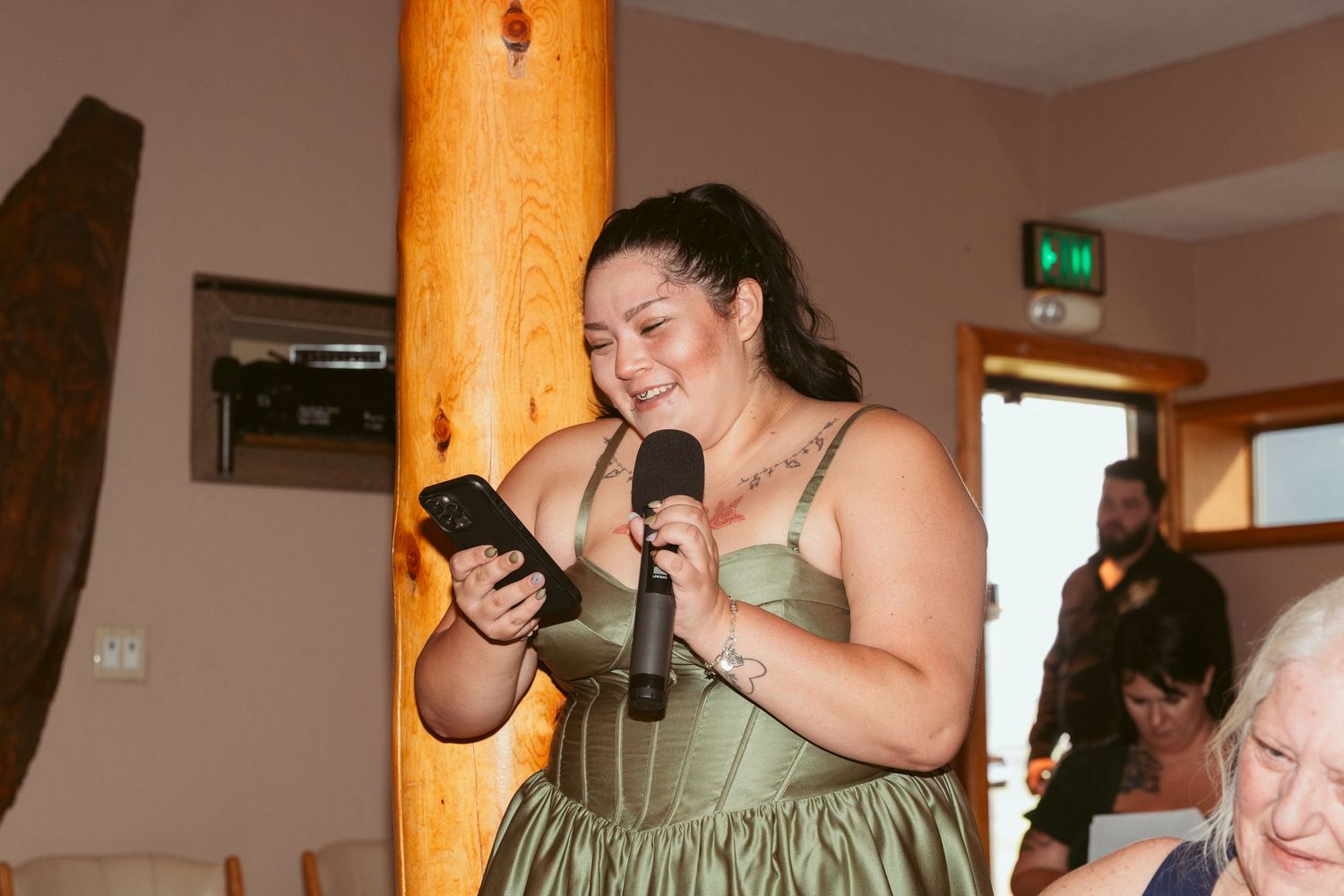 Wedding reception party inside a rustic lodge with wooden beam details.