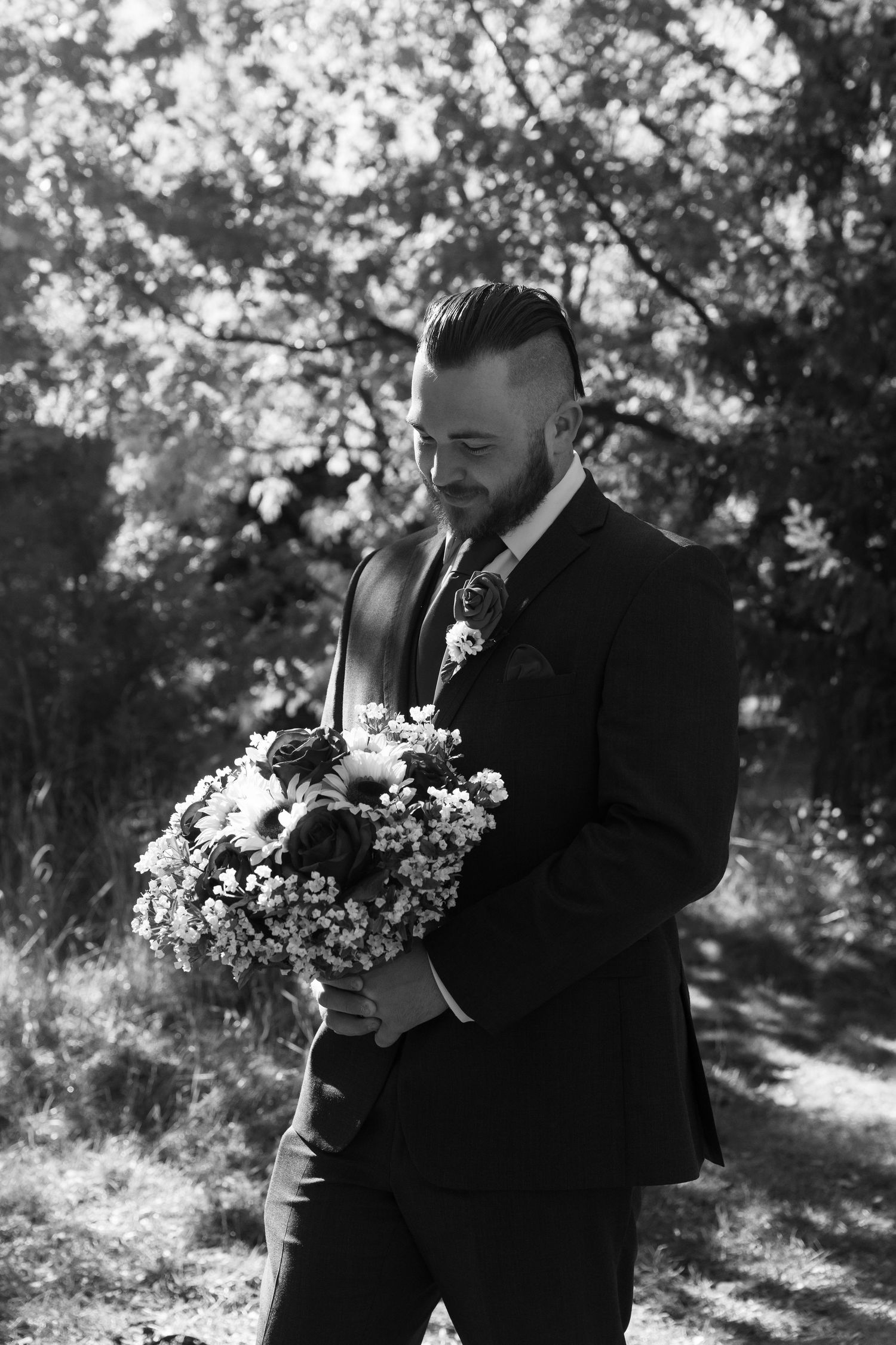Black and white portraits of wedding party members holding floral bouquets in a wooded setting.