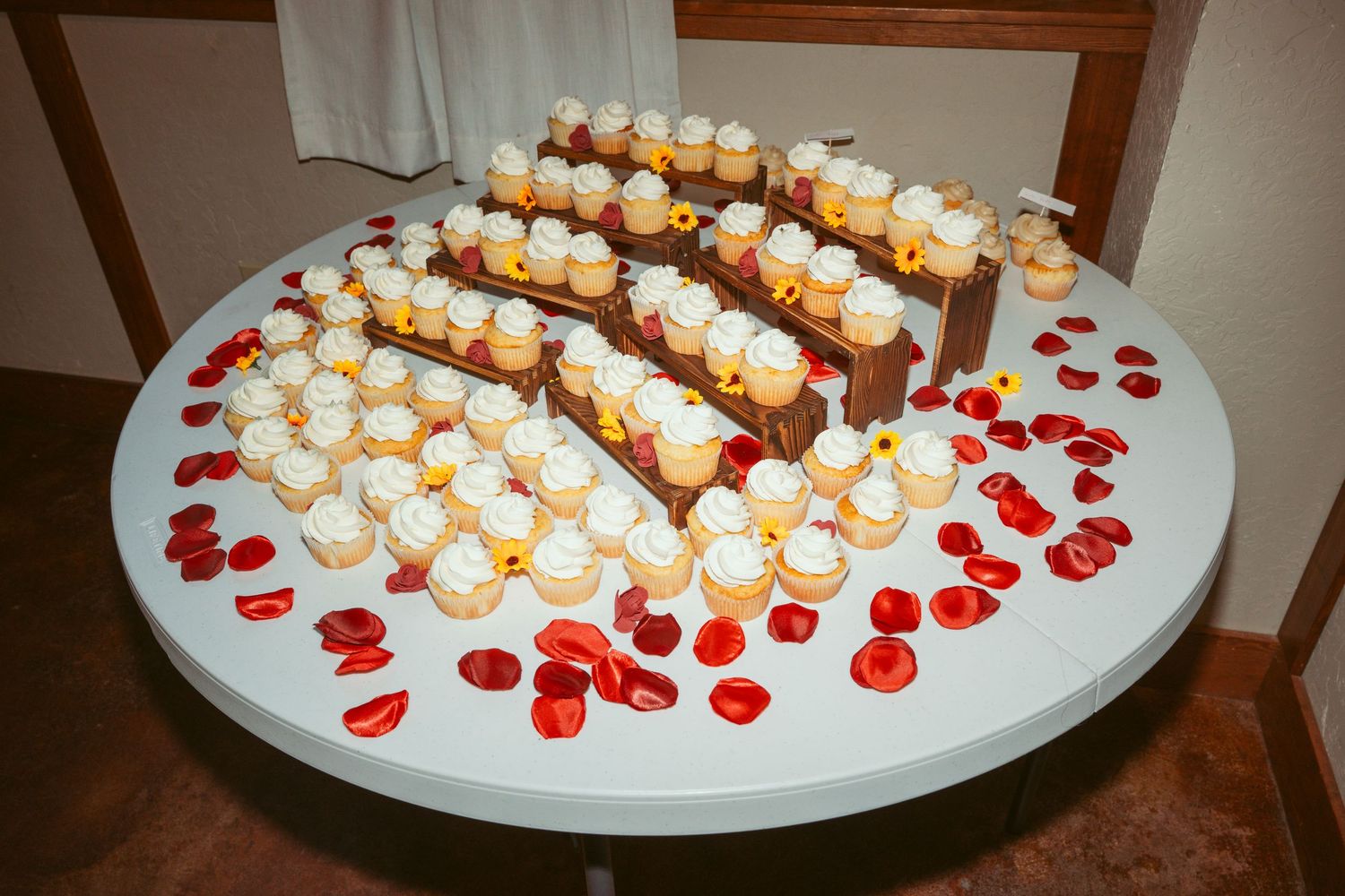 Tiered display of cupcakes arranged in a circular pattern on a white platform.