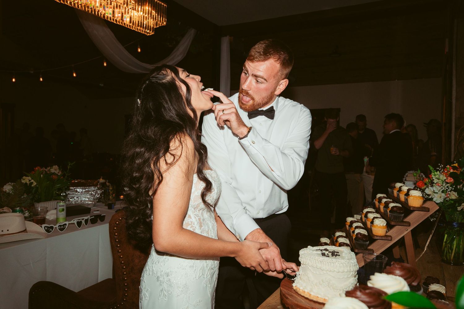 Couple participates in traditional cake cutting ceremony at their wedding reception.
