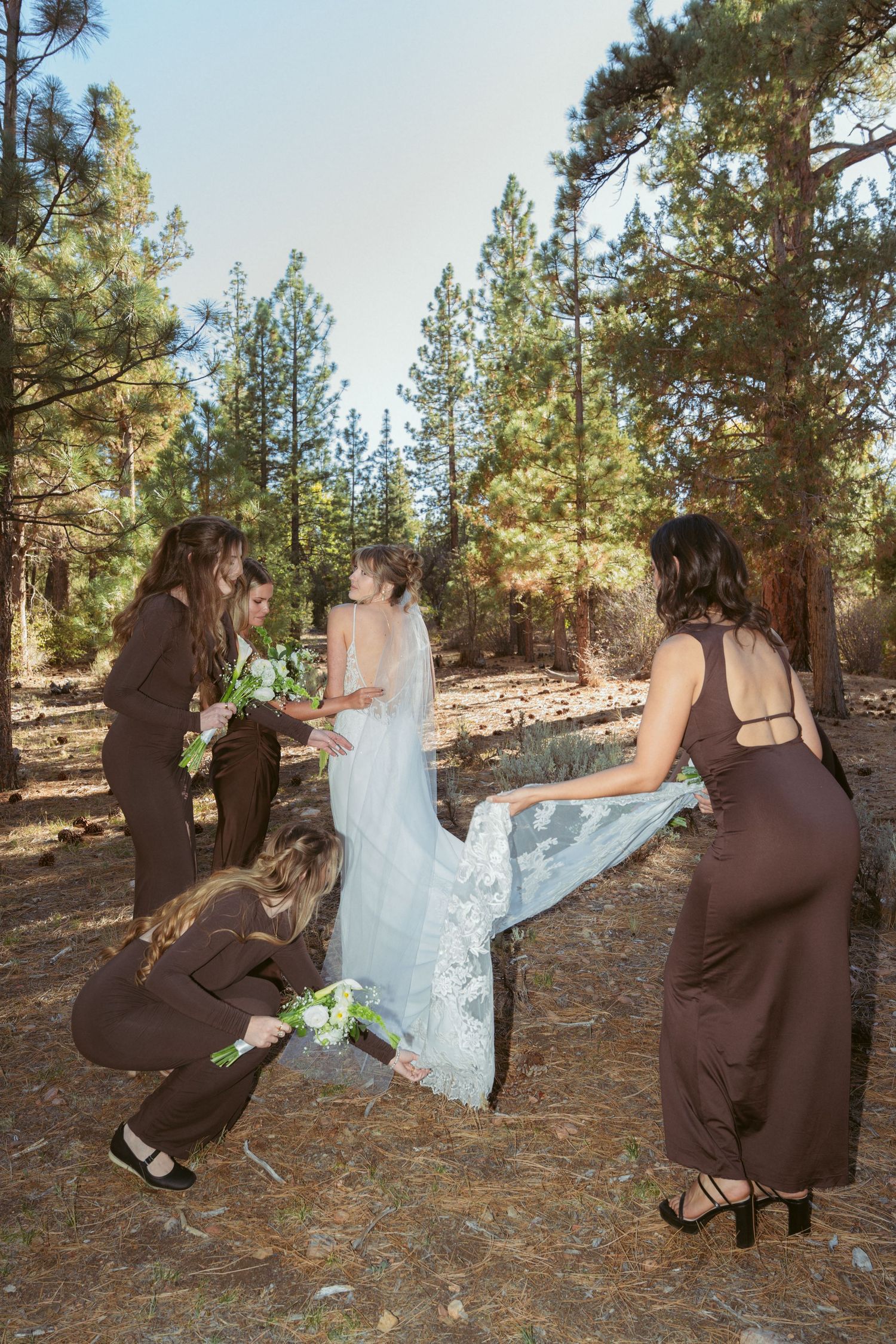 Playful wedding photo sequence showing bridal party members falling down in a forest setting.