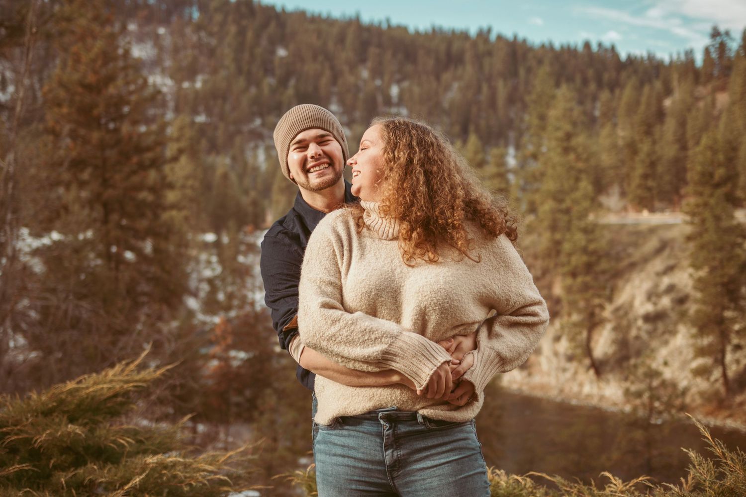 Couple enjoying a candid moment together on a mountain trail during winter.