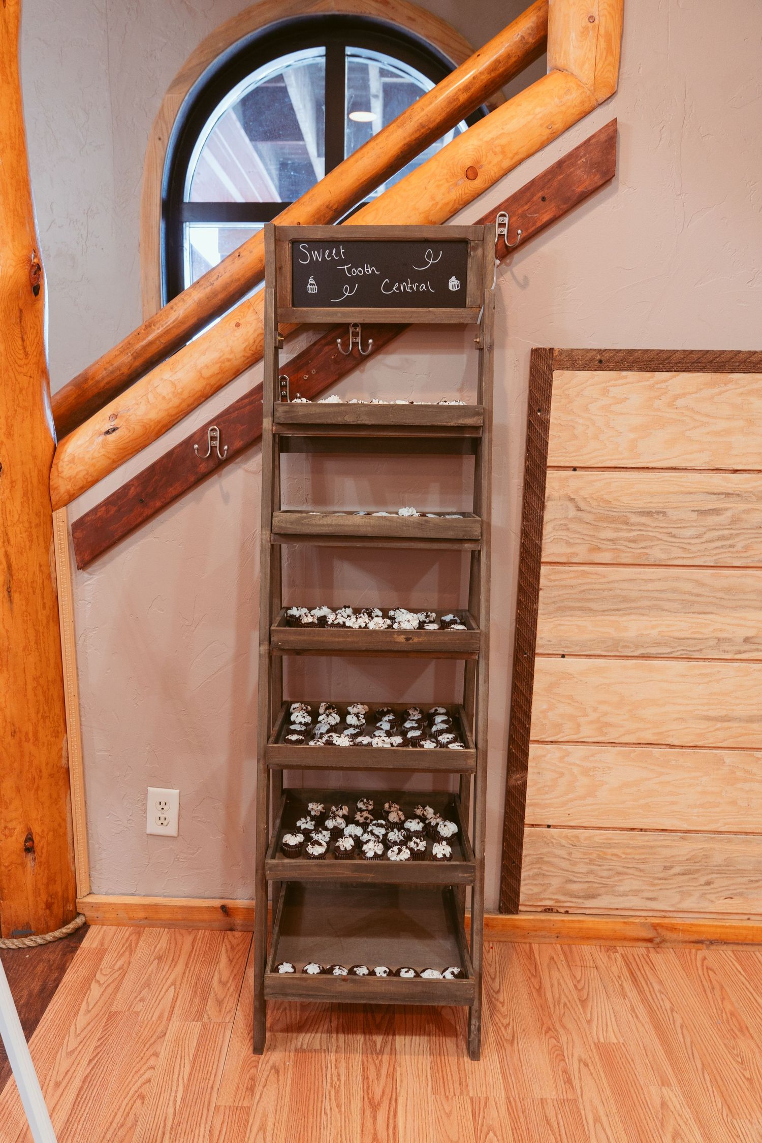 Wooden shelving unit displaying rows of small white boxes or cases against a light colored wall.